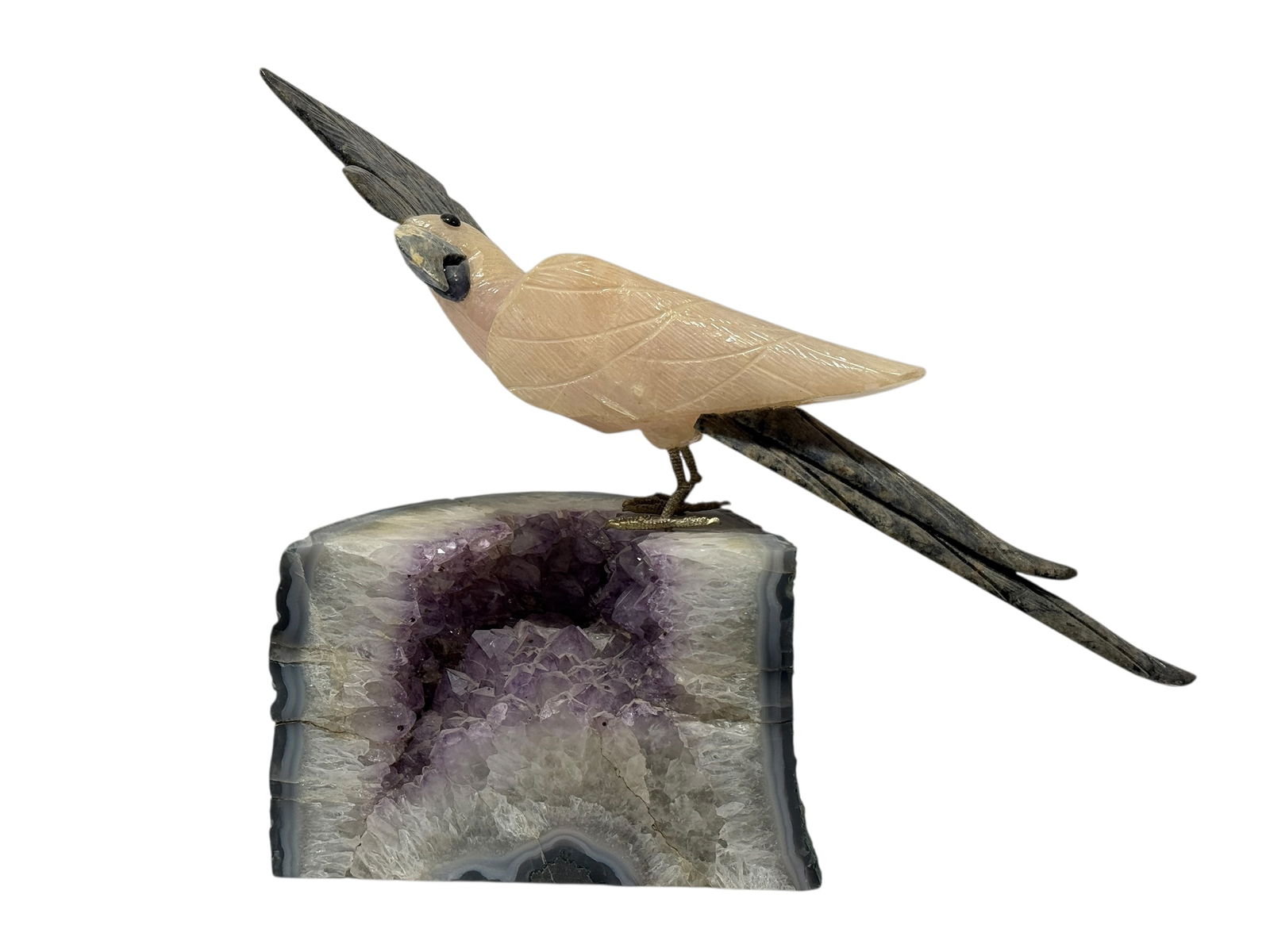 Hardstone Bird Sculpture on Amethyst Geode Base: Hardstone Bird Sculpture on Amethyst Geode Base. Carved hardstone bird sculpture depicted perched on a natural amethyst geode base. The bird is rendered in a pale translucent stone with finely incised