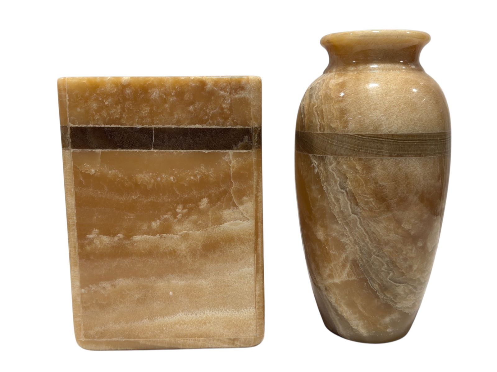 (2) Decorative Onyx Stone Vessels: (2) Decorative Onyx Stone Vessels. Group of 2 coordinating decorative vessels carved from banded honey-toned onyx stone, offered together as one lot. The lot includes a cylindrical vase with a gently