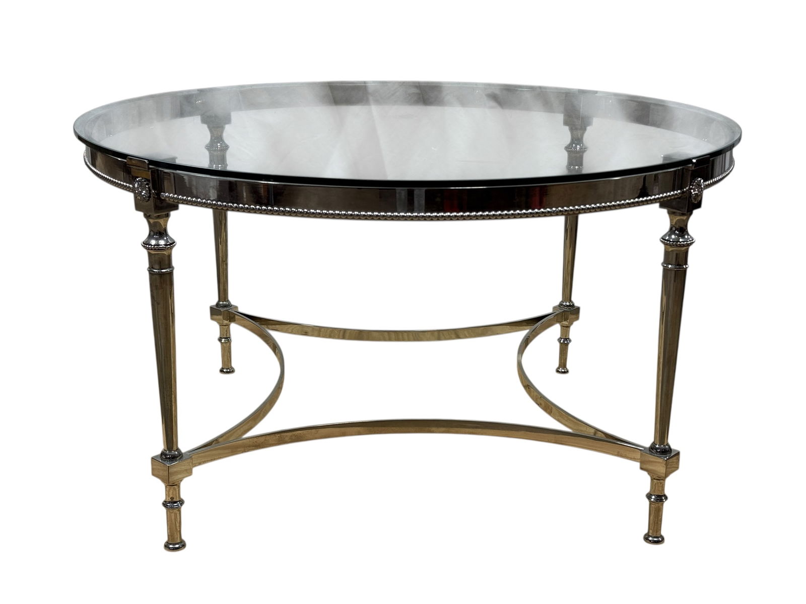 Maison Jansen Style Silverplate & Glass Table: Elegant Maison Jansen style oval table featuring a clear glass top set into a silverplate frame. The table is supported by four tapered legs with square bases, connected by graceful curved stretchers