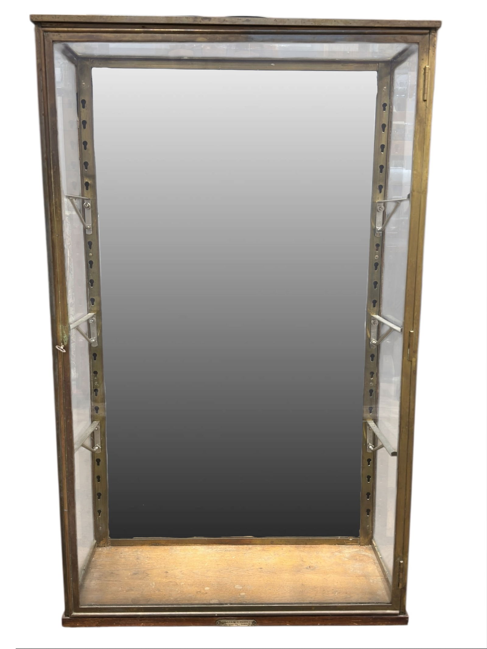 1920s French William of Paris Brass & Glass Cabinet: 1920s French William of Paris Brass & Glass Cabinet. Has label on the front near base, under door. Has a mirrored back and can be hung on the wall. Measures 41" H x 24" W x 10" D. Condition reflects i