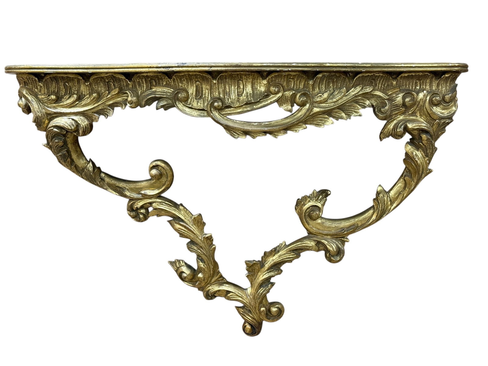 Antique Italian Giltwood Wall Console Table: An antique Italian giltwood wall console table, marked “Made in Italy” on the underside, featuring exuberant Rococo-style scrolling acanthus carvings, a shaped serpentine top, and dramatic fol