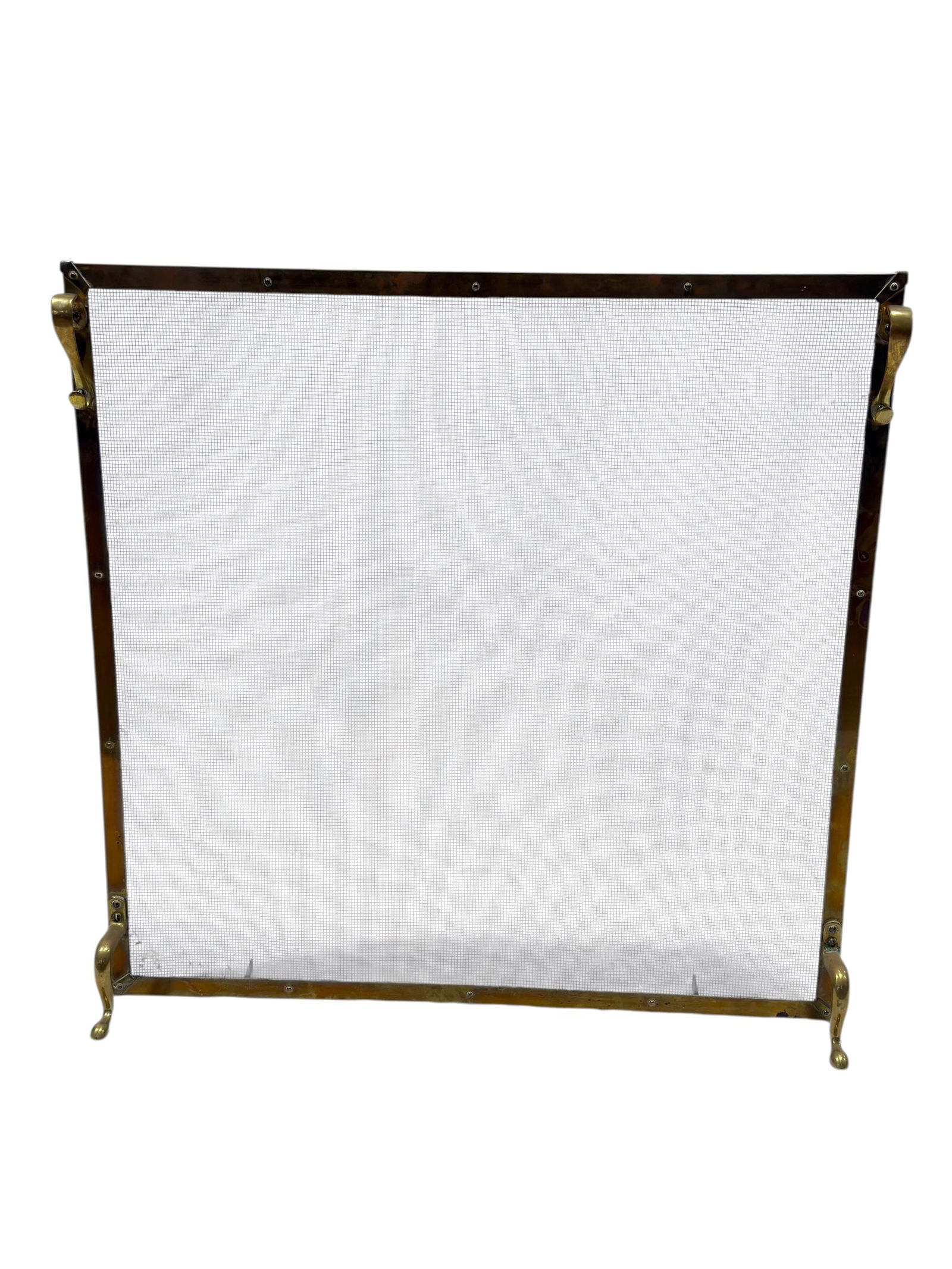 Brass & Wire Mesh Fireplace Fire Screen: Rectangular brass-framed fireplace fire screen featuring a fine woven wire mesh panel, brass side handles, and shaped brass feet allowing it to stand freely in front of a hearth, likely mid-20th centu