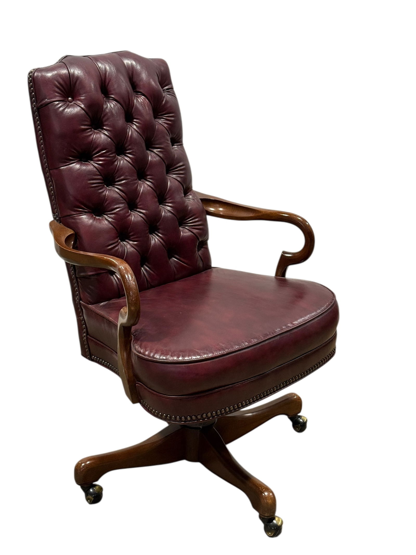 Tufted Burgundy Leather Executive Swivel Armchair: This classic executive swivel armchair features deep burgundy button-tufted leather upholstery with a tall, generously padded back and seat, complemented by smoothly curved solid wood arms and a match
