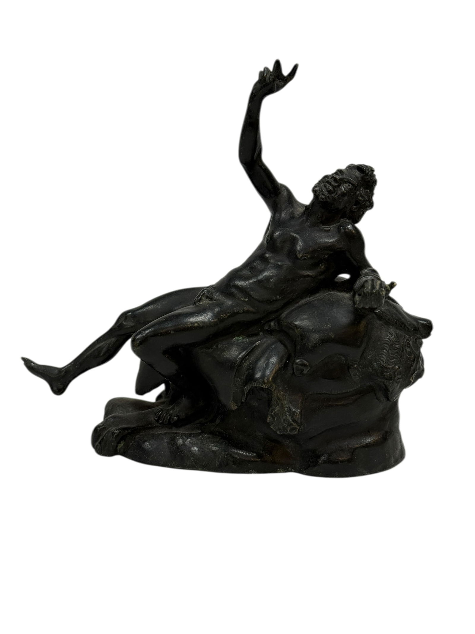 19th Century Grand Tour Bronze Figure of Bacchus Reclining: This striking Grand Tour bronze depicts Bacchus, the classical Roman god of wine and revelry, shown in a dramatic reclining pose atop a naturalistic rocky mound. The figure is beautifully modeled