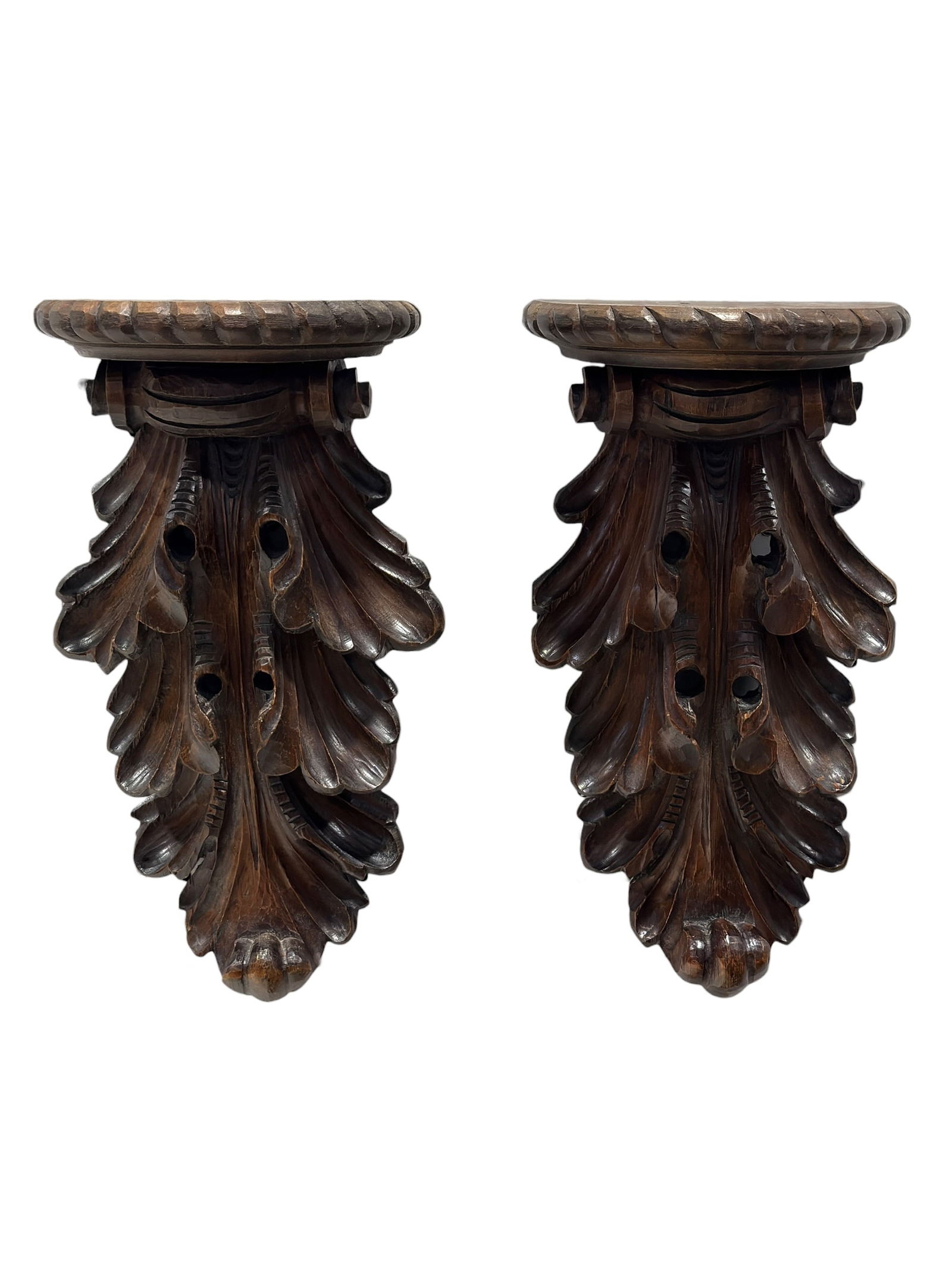 Pair of Italian Carved Wood Acanthus Leaf Form Wall Brackets: Decorative pair of carved wood wall brackets in an Italian style, featuring dramatic acanthus leaf scrollwork with a rich dark stained finish and shaped half-moon display shelves at the top. These arc