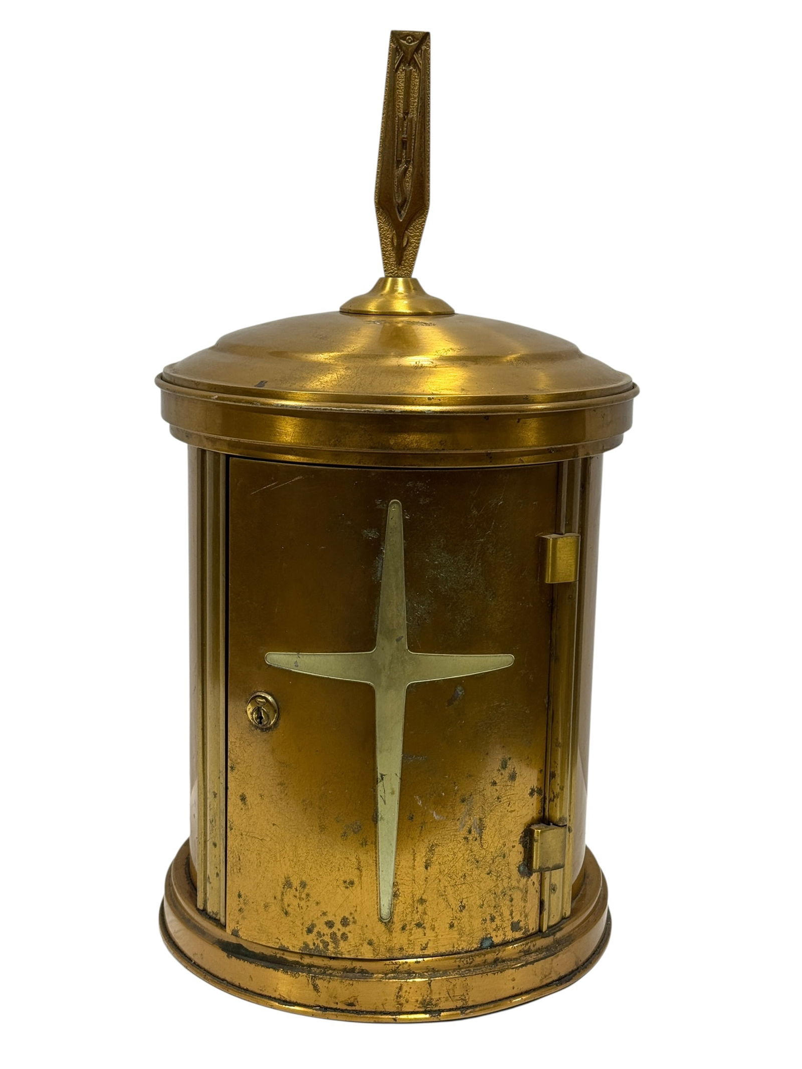 Art Deco Brass Church Tabernacle or Reliquary Cabinet: Early to mid-20th century Art Deco ecclesiastical brass tabernacle of cylindrical form, the domed top surmounted by a vertical finial cast with stylized cross and geometric ornament, the front fitted