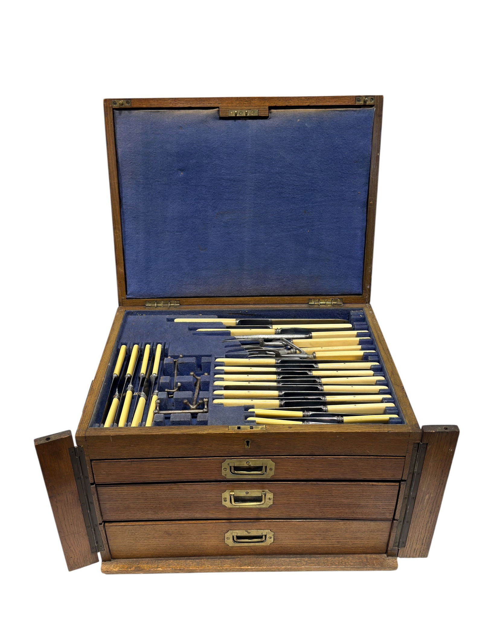 (36pcs) Bone-Handled Flatware Service in Oak Case w/ Knife Rests: 36-piece flatware service housed in a fitted oak canteen with brass campaign-style handles and three graduated drawers, the interior lined in blue felt and labeled for various forms including “Tea S