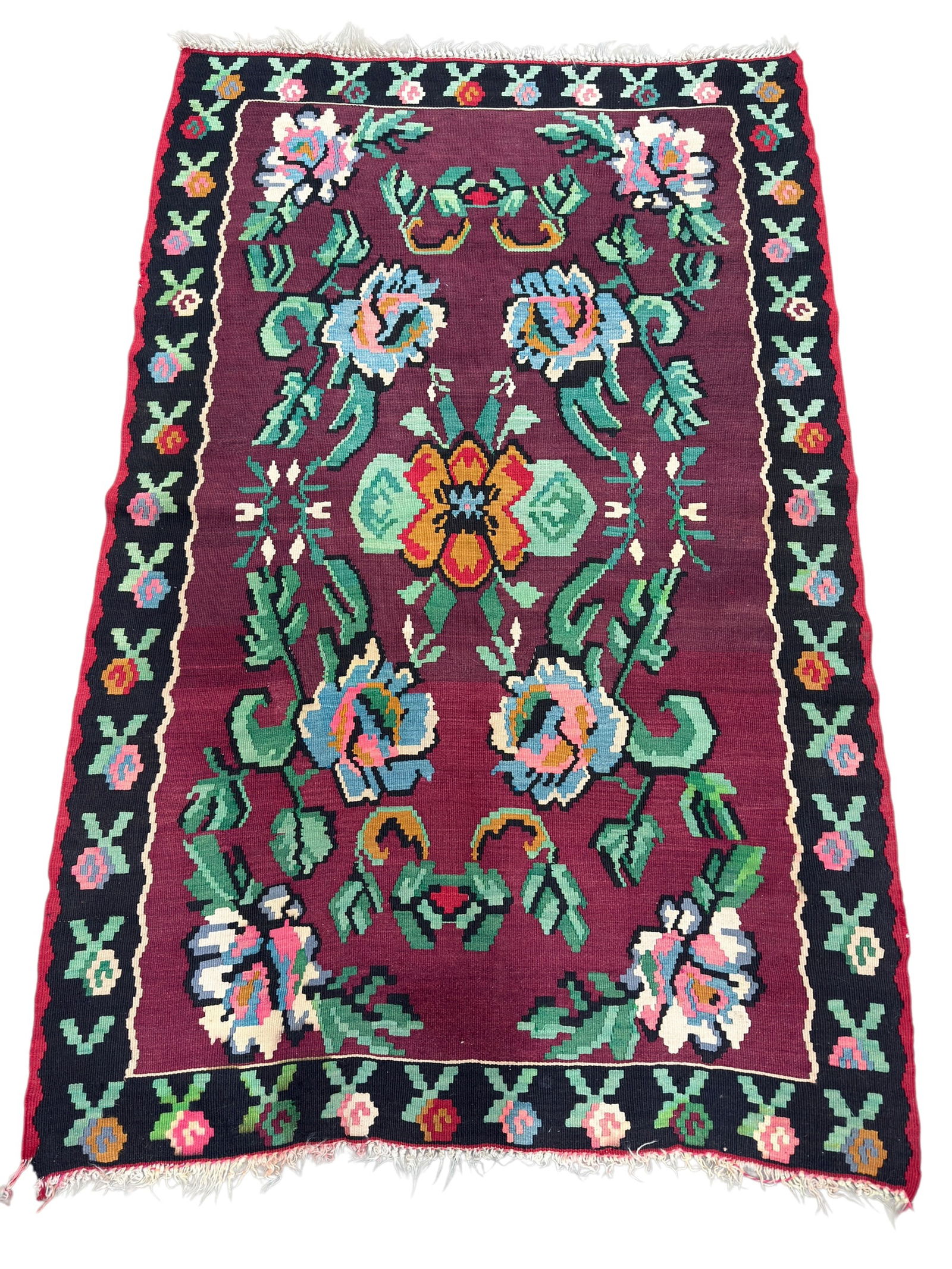 Handwoven Floral Kilim-Style Area Rug: Handwoven kilim-style area rug featuring a rich burgundy field centered with a bold stylized floral medallion and surrounded by large scrolling blossoms and leafy vines in shades of blue, pink, ivory,
