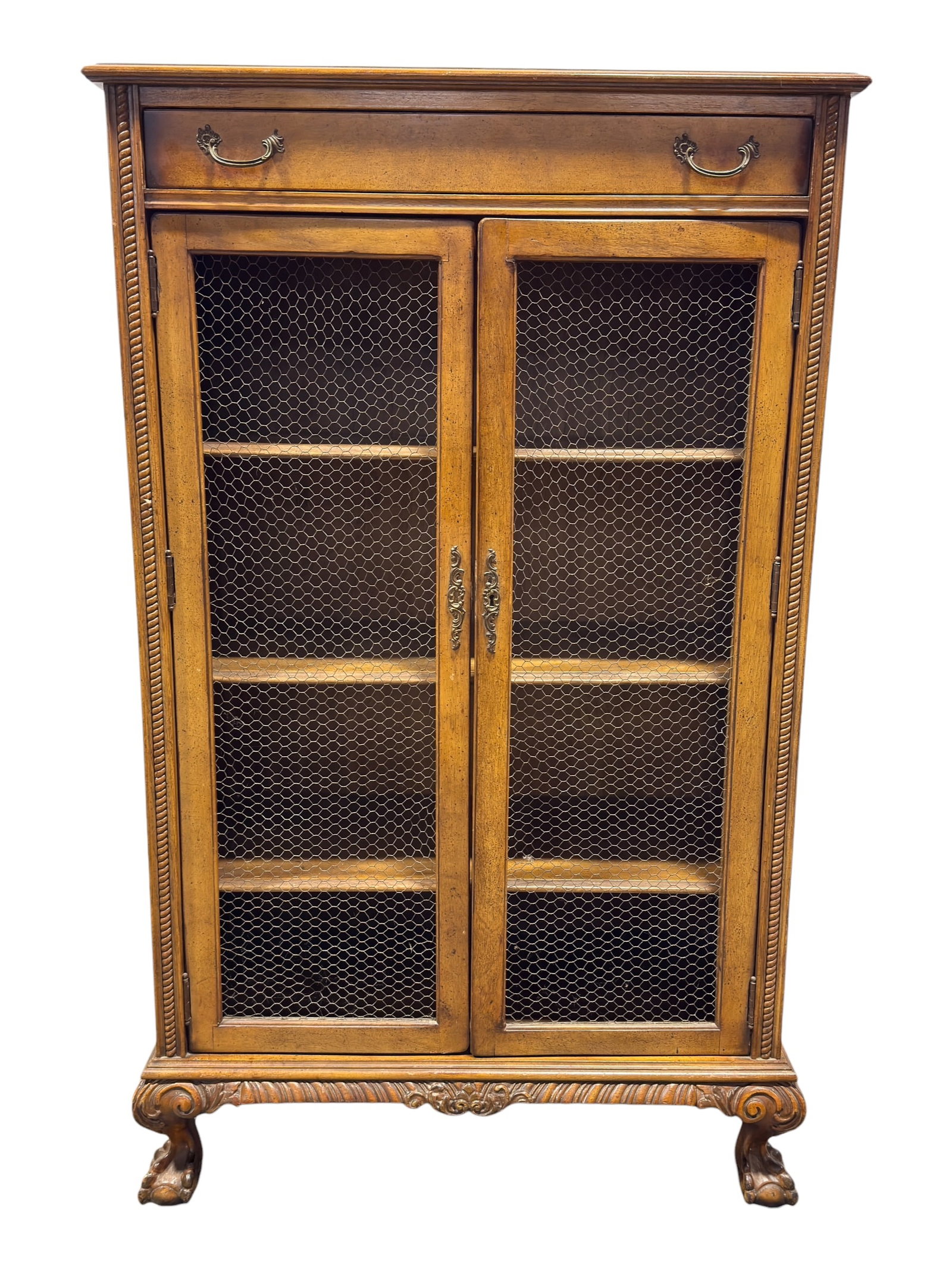 Vintage Country French Style Cabinet w/ Drawer: Charming late 20th century Country French style cabinet crafted in a warm medium-tone wood, featuring a rectangular case fitted with a single upper drawer over a pair of hinged doors inset with decora