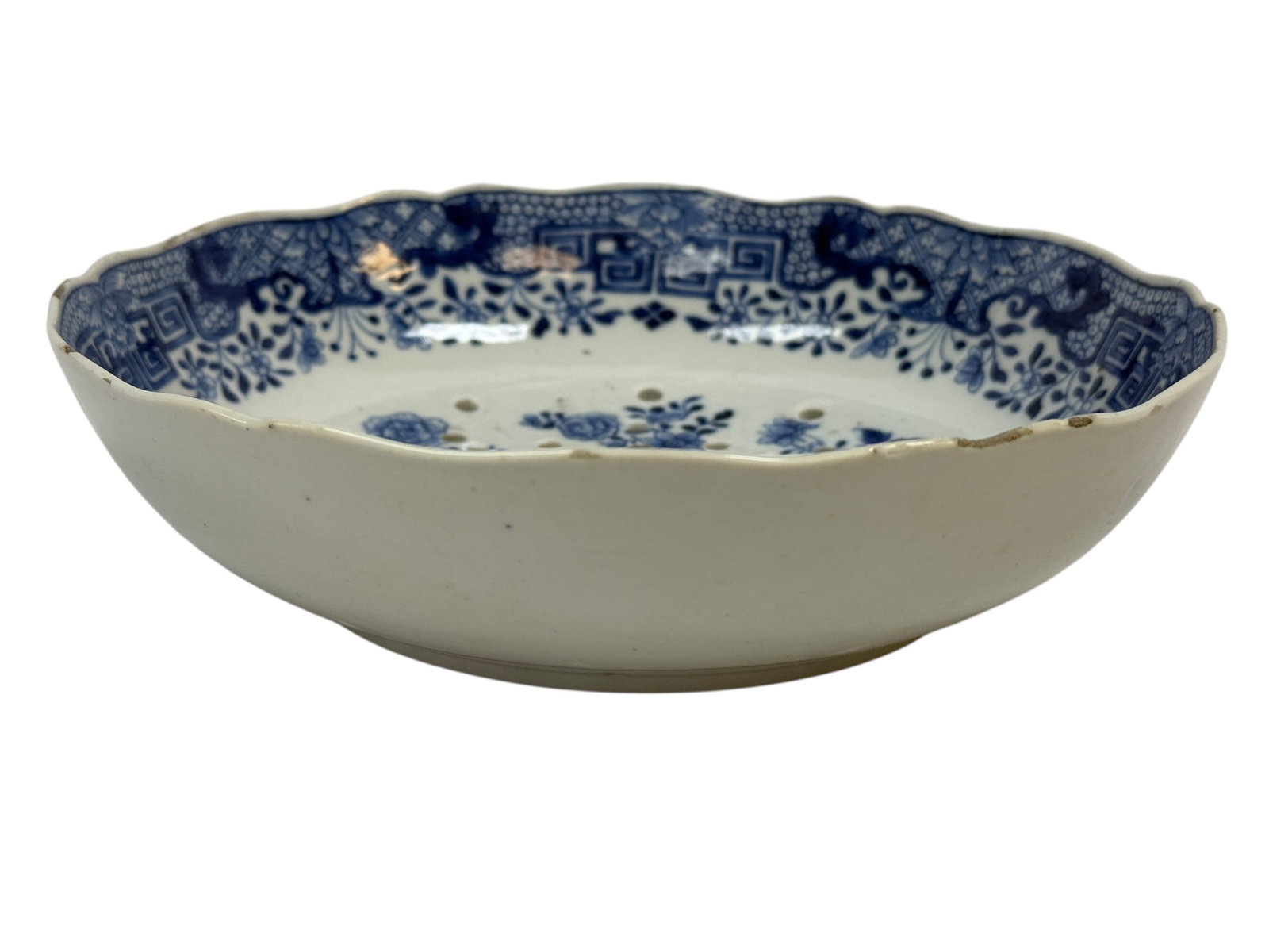 Late 19th C. Qing Dynasty Chinese Porcelain Reticulated Strainer Bowl: A late 19th century finely potted Chinese Qing Dynasty blue and white porcelain strainer bowl of shallow, lobed form, the interior richly decorated with a central floral spray surrounded by scattered