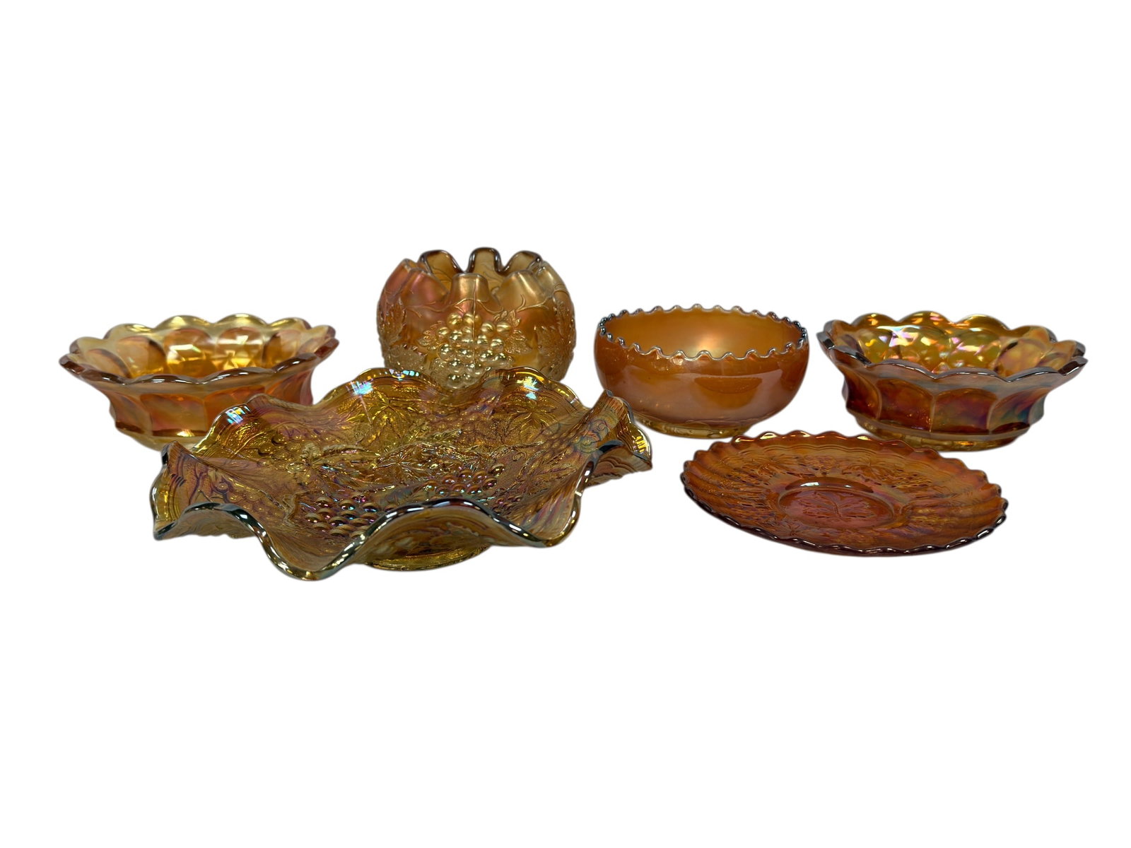 (6) Early 20th C. Marigold Carnival Glass Grape Pattern Pieces: A richly colored and visually striking group of six early 20th century carnival glass pieces in the popular grape and vine pattern, executed in luminous marigold iridescence with strong flashes of gol