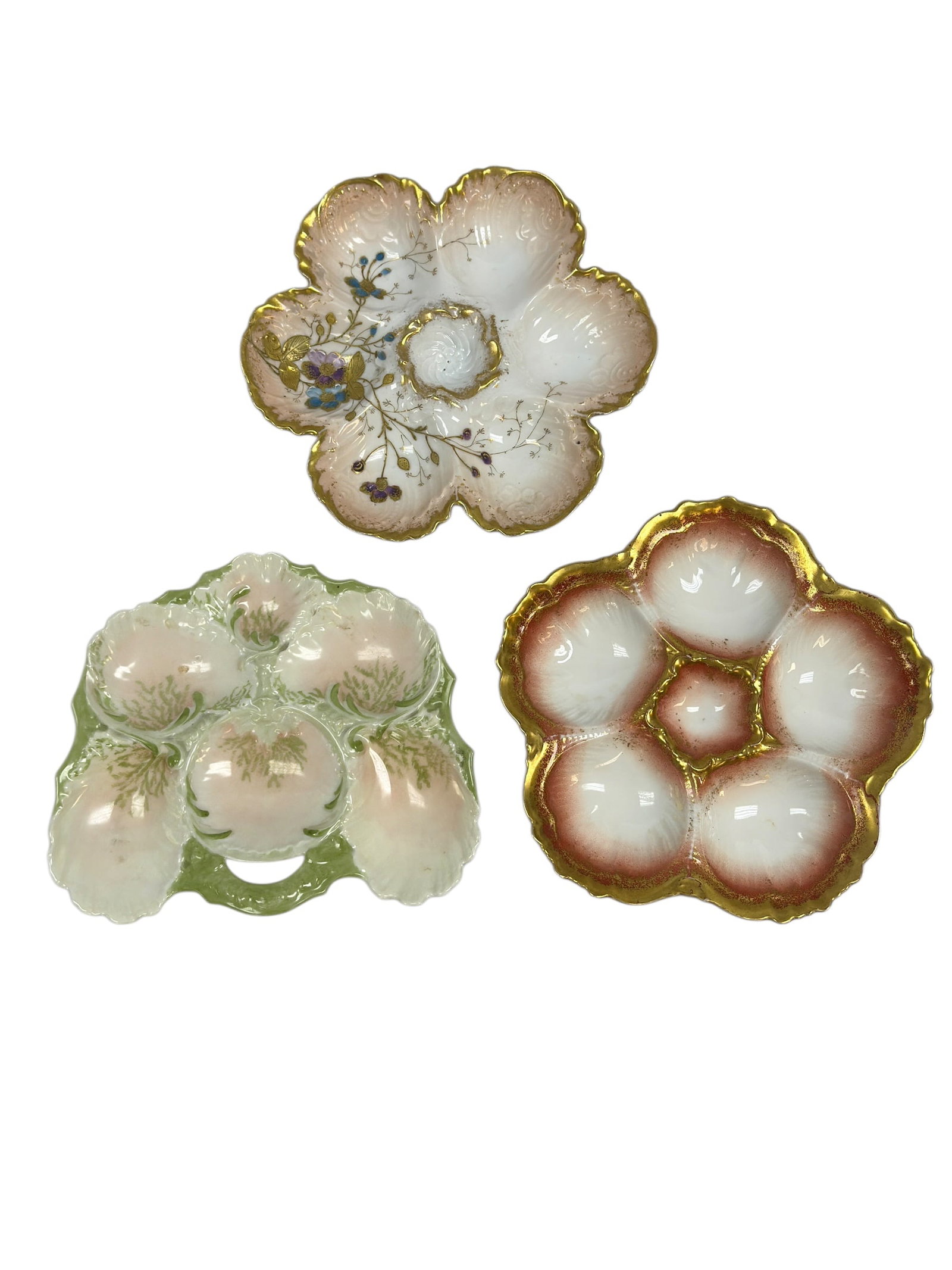 (3) Antique French Porcelain Oyster / Egg Serving Dishes: A charming group of three antique French porcelain oyster or egg serving dishes, each formed with multiple scalloped wells surrounding a central sauce or garnish reservoir, including one finely decora