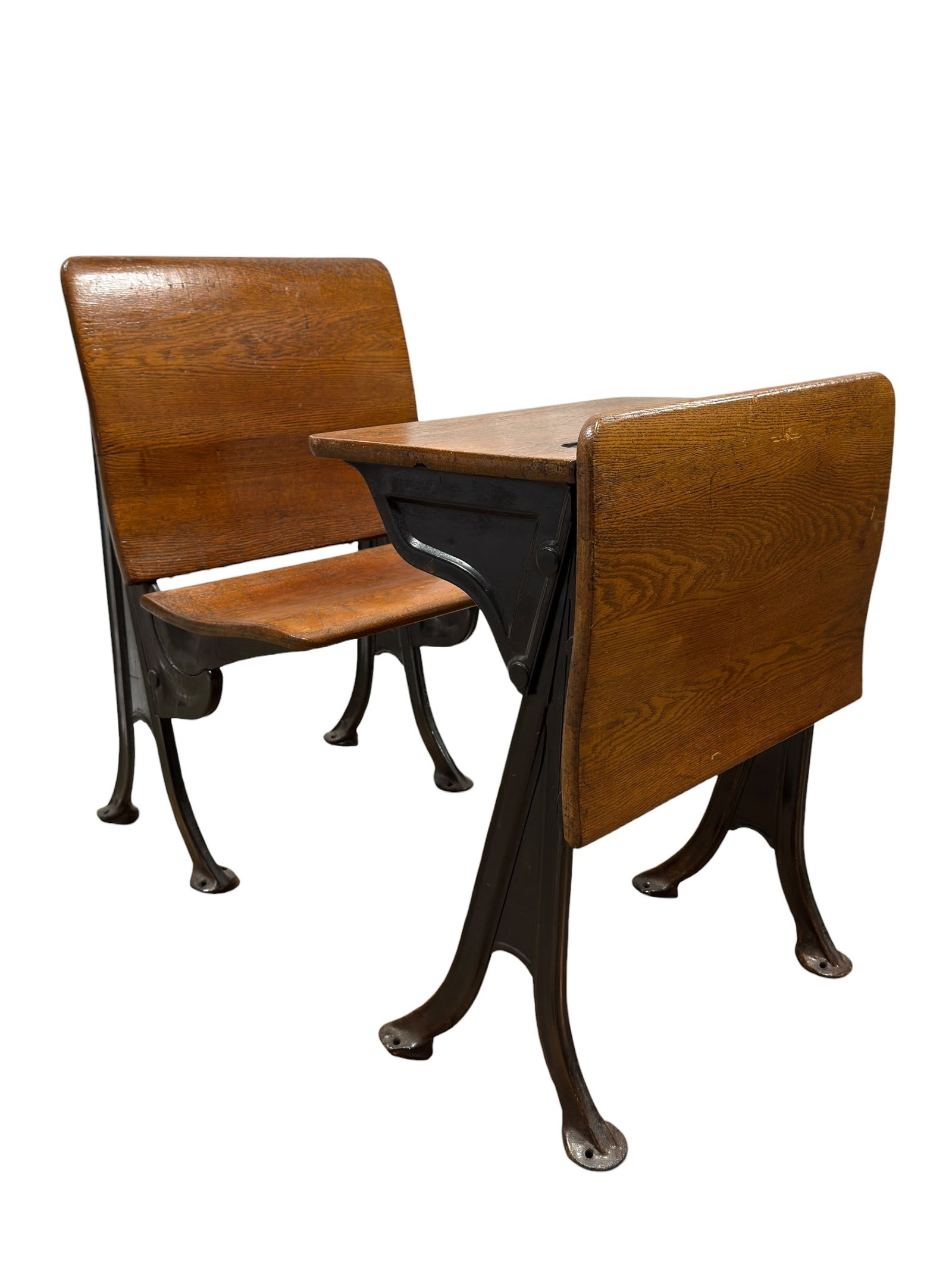 Circa 1900 American Seating Co. Style Quarter-Sawn Oak & Cast Iron School Desk: A classic turn-of-the-century American school desk in the manner of American Seating Company, circa 1900, featuring a richly grained quarter-sawn oak writing surface and matching curved seat mounted t