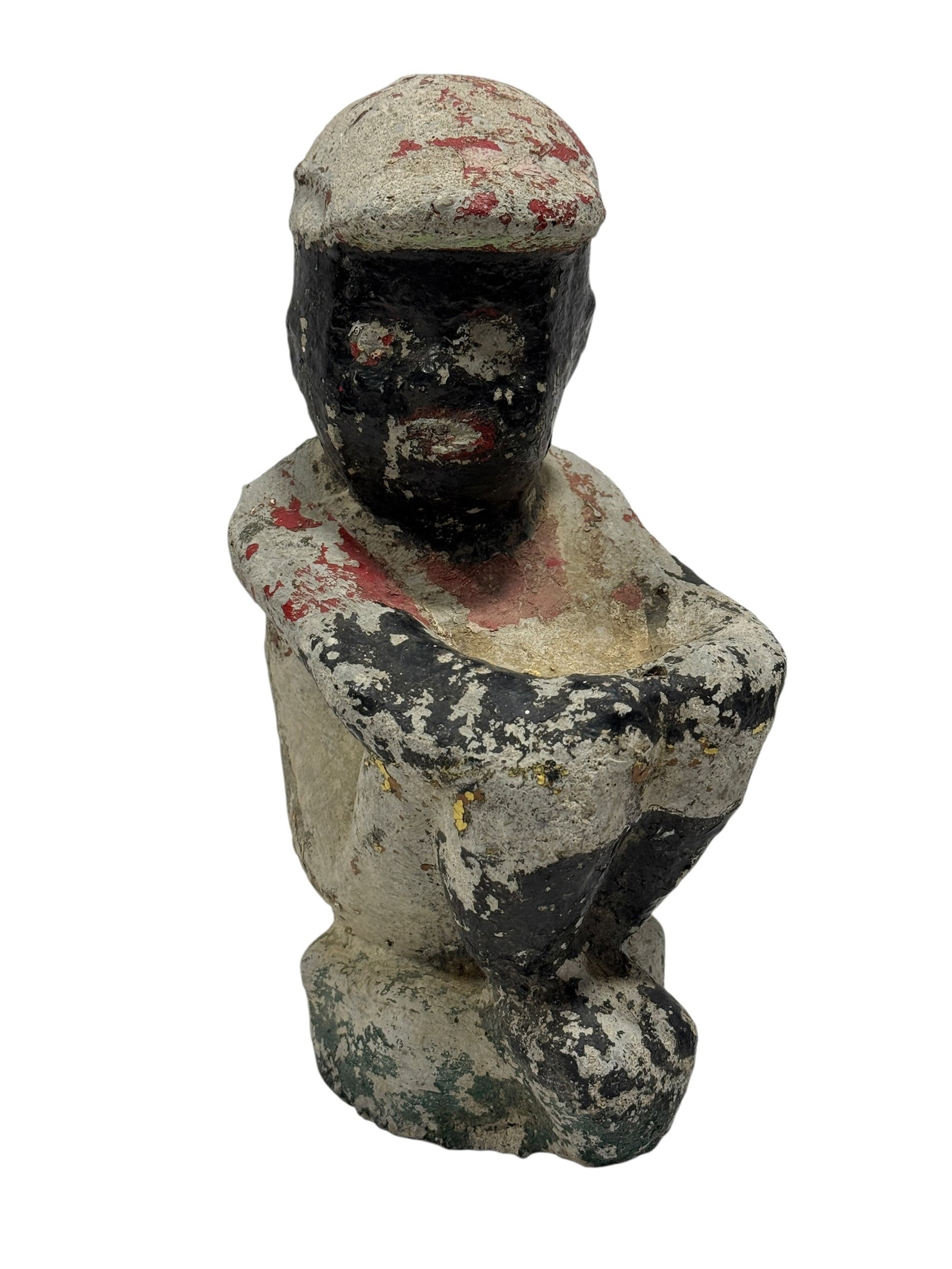Vintage Folk Art Painted Concrete Figure of Seated Man: Vintage folk art painted concrete figure depicting a seated male figure with arms wrapped around his knees, wearing a cap and rendered in a naïve, hand-formed style, the surface showing layered paint