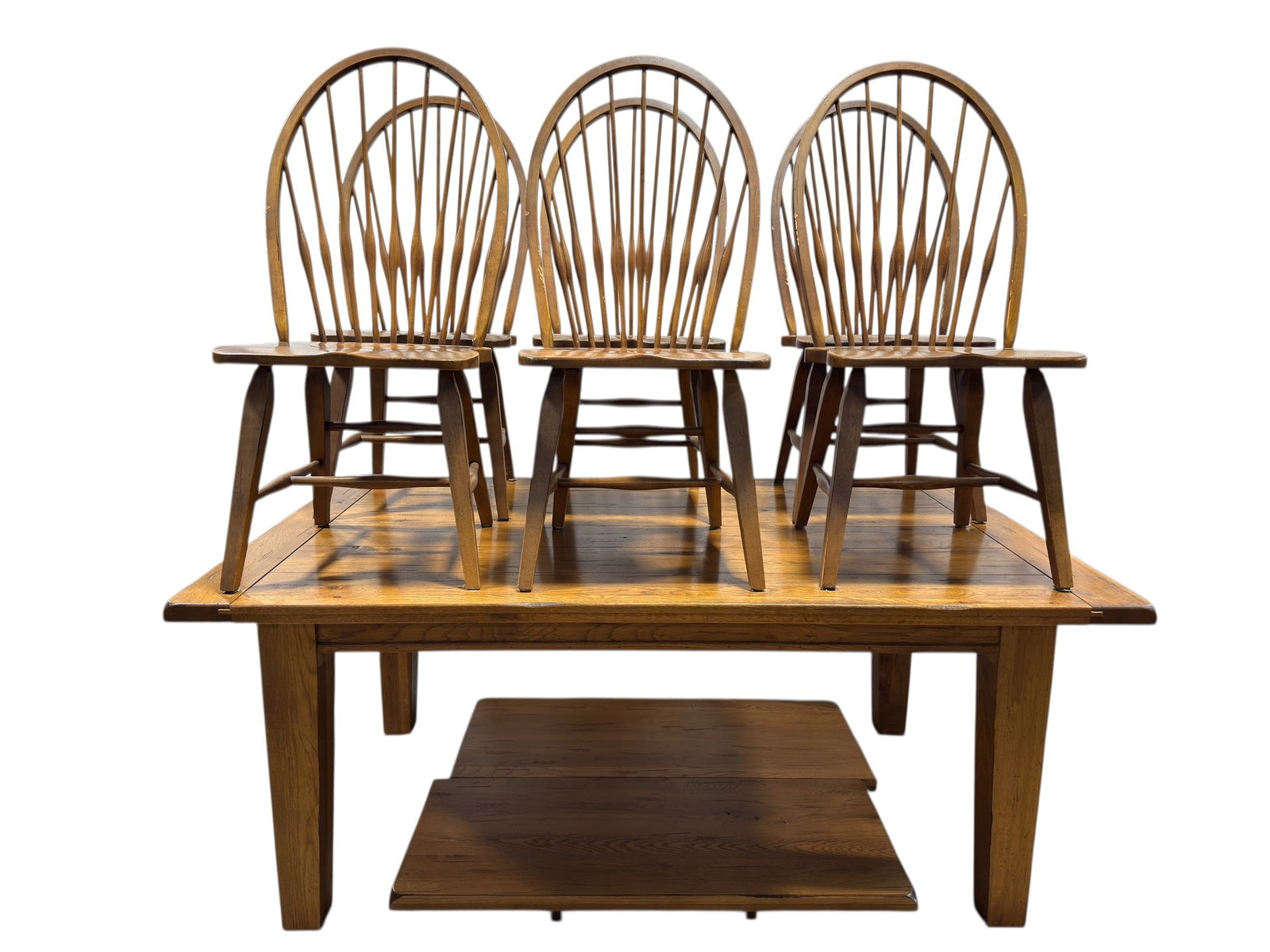 Oak Farmhouse Style Dining Table w/ 6 Windsor Chairs: A substantial farmhouse-style dining table crafted in oak, featuring a plank-top surface with breadboard-style ends and a warm medium-toned finish, raised on sturdy square legs with a clean, rustic pr