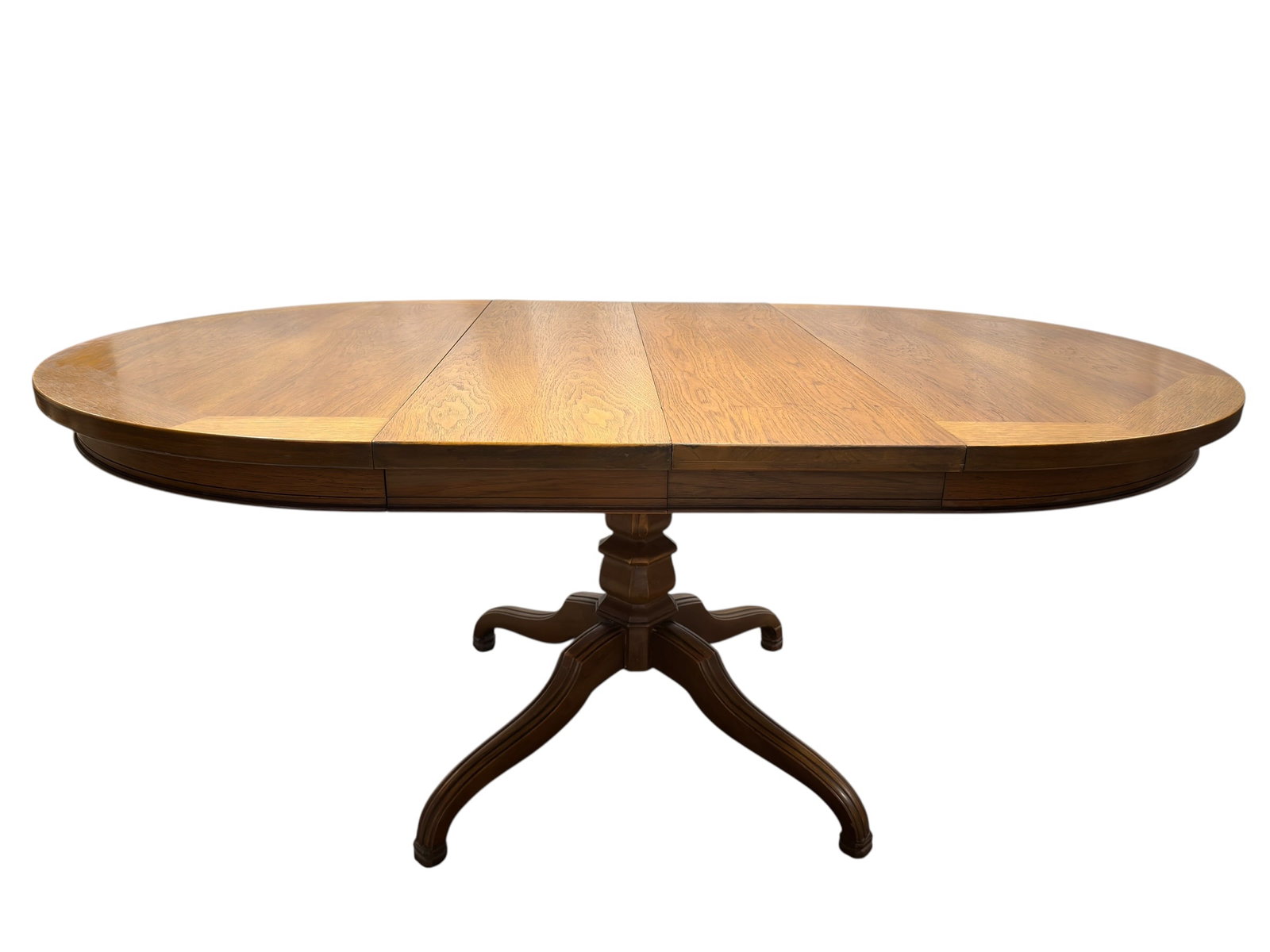 Oak Pedestal Dining Table w/ 2 Leaves: Substantial dining table crafted in warm-toned oak, featuring an oval top with bookmatched veneer grain and contrasting banded border, raised on a turned central pedestal with four gracefully curved,