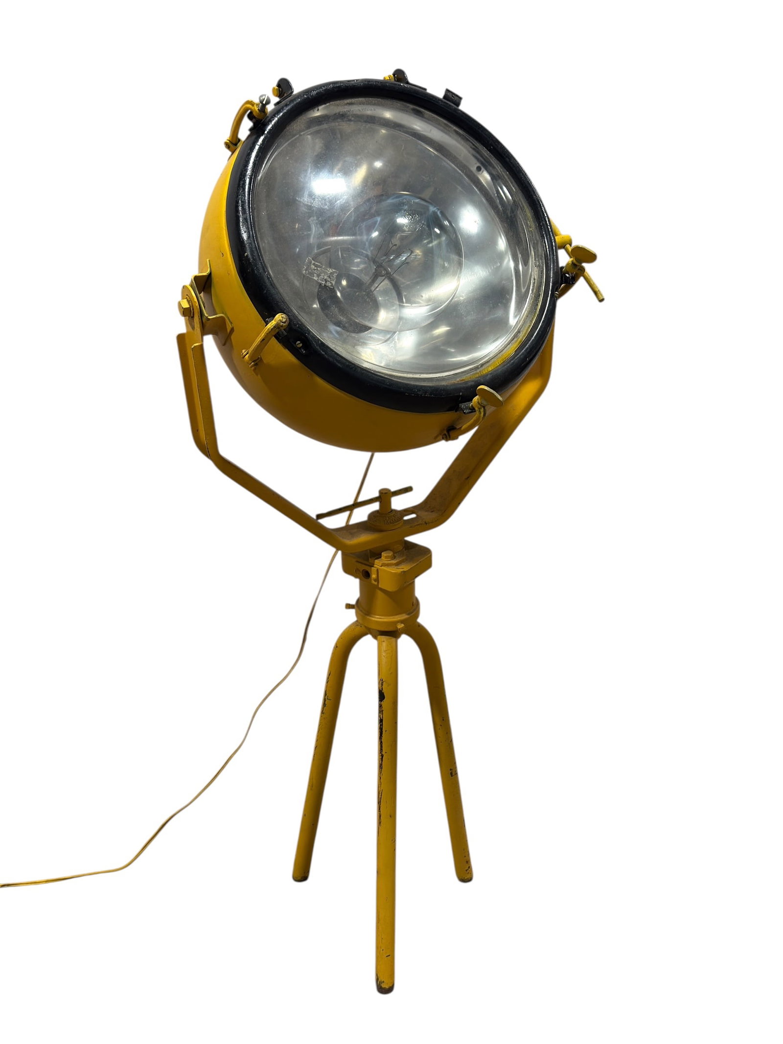 Vintage Industrial Tripod Spotlight / Searchlight: Striking industrial spotlight featuring a large circular metal housing in bold yellow with a black rim, mounted on an adjustable yoke and sturdy three-leg tripod base, the lamp housing fitted with a