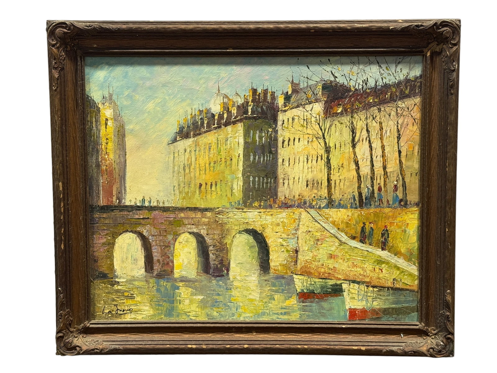Signed 20th Century French Cityscape Bridge Oil on Canvas: Signed oil on canvas depicting an atmospheric French cityscape with a stone bridge spanning a tranquil river, bustling figures strolling along the embankment, moored boats, and elegant Parisian-style 