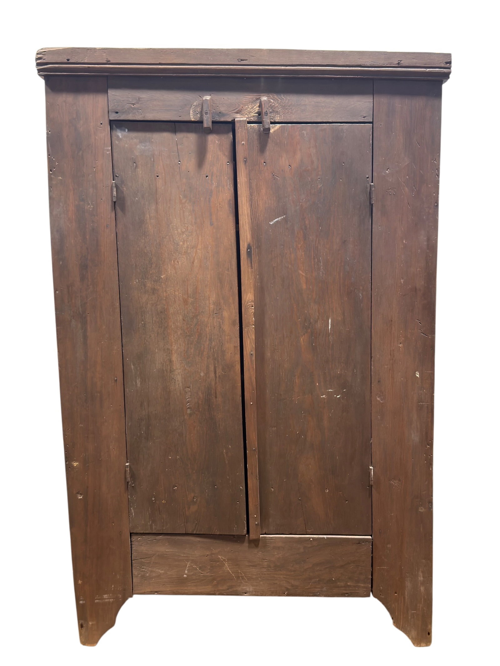 19th Century American Primitive Pine Cupboard: A fine 19th century American Primitive pine cupboard featuring a molded cornice above a pair of full-height plank doors retaining their original wooden pintle hinges and simple wooden turn latches, op