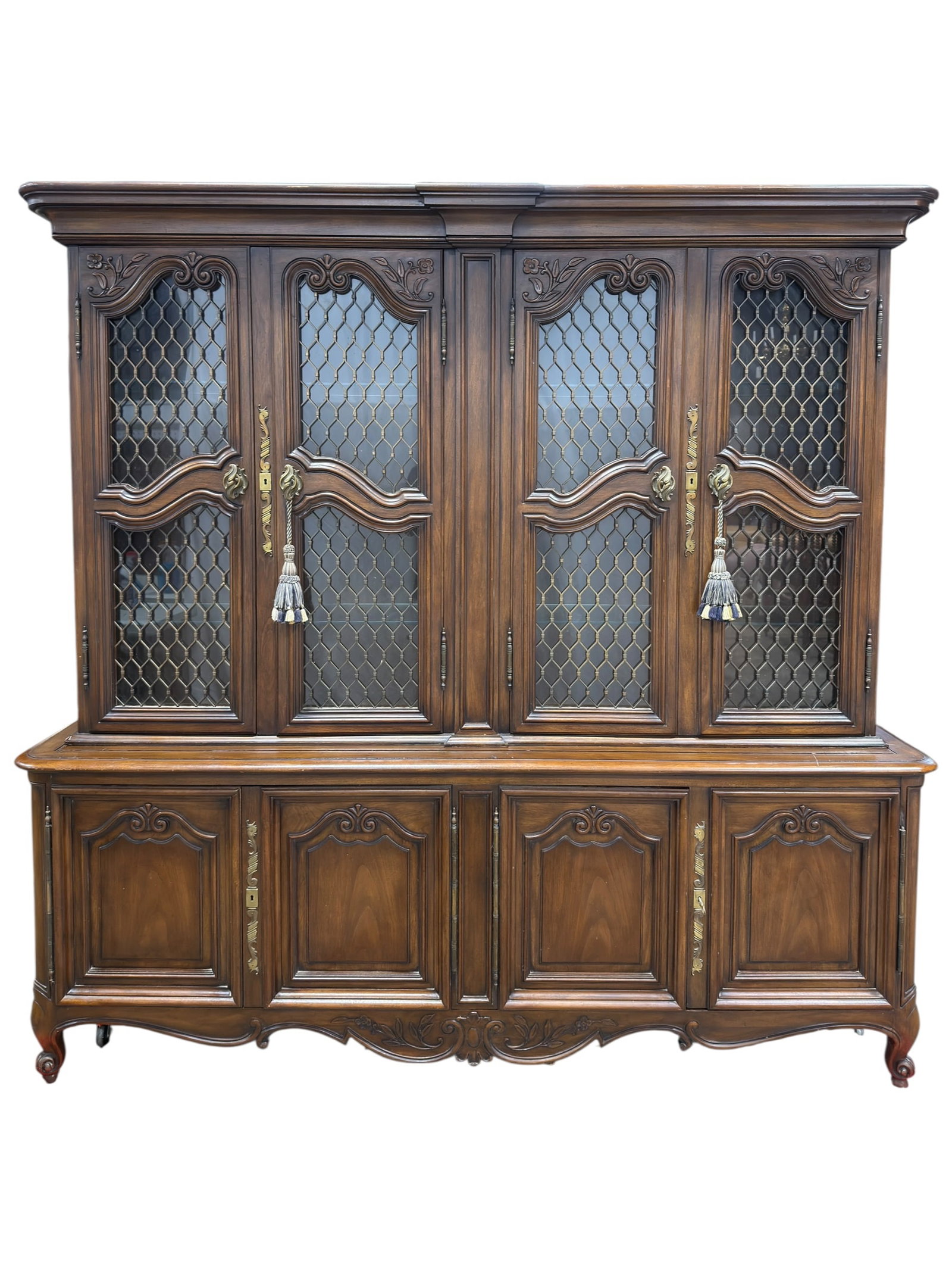 Mid-Late 20th Century French Provincial Style Walnut China Cabinet: Mid to late 20th century French Provincial style two-piece walnut china cabinet, featuring an upper display section with four shaped leaded glass doors opening to adjustable glass shelves, and a lower