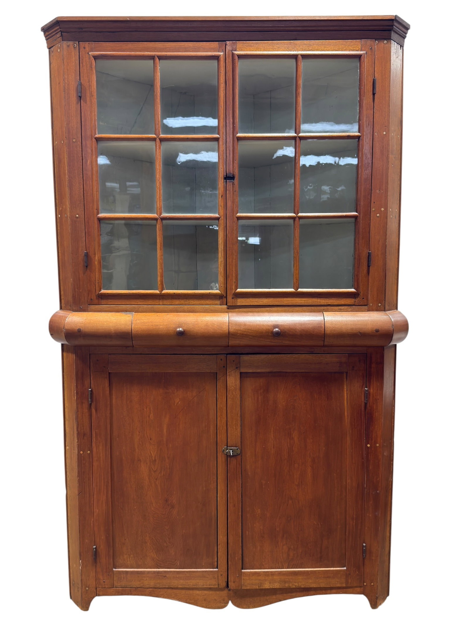 Primitive American Corner Cabinet: This classic American primitive corner cabinet is constructed as a single cohesive unit with a warm, naturally aged pine and mixed hardwood finish. The upper section features a molded crown piece over