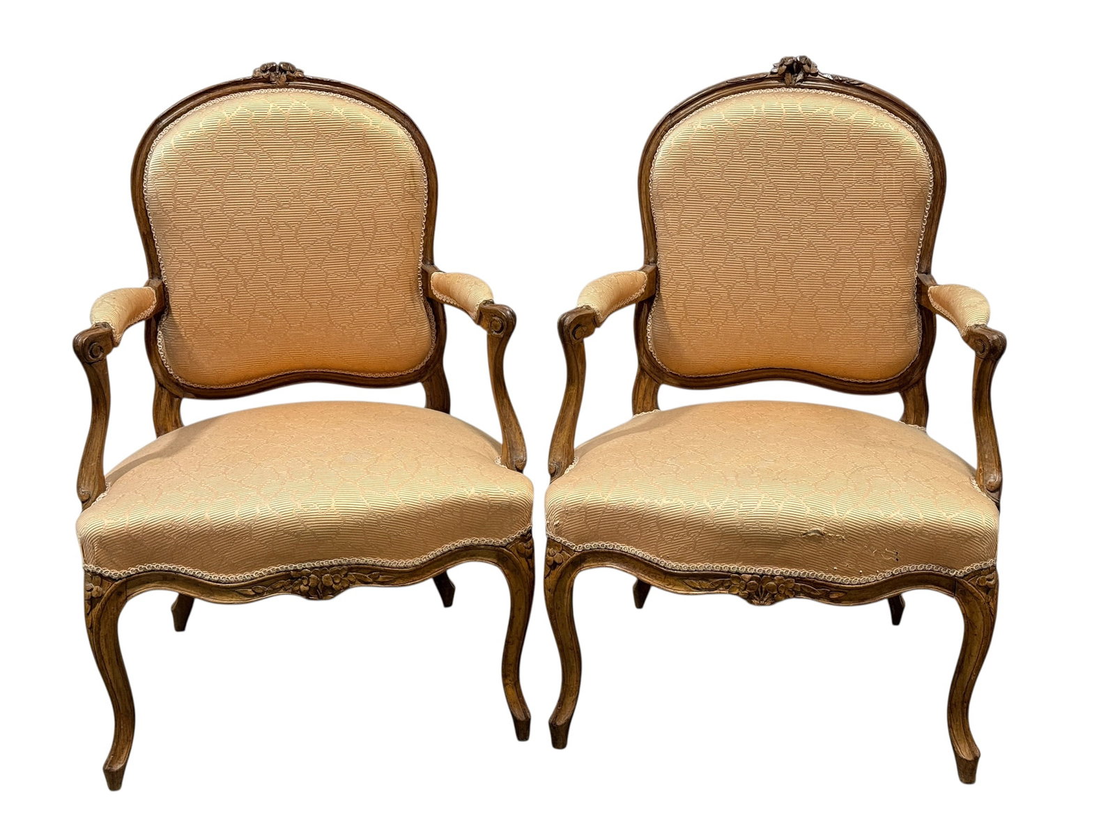 Pair of French 18th Century Beechwood Fauteuil Armchairs: Attractive pair of French 18th century beechwood fauteuil armchairs featuring molded and carved frames with shaped crest rails, serpentine aprons, scrolling arms, and elegant cabriole legs. Hand-carve