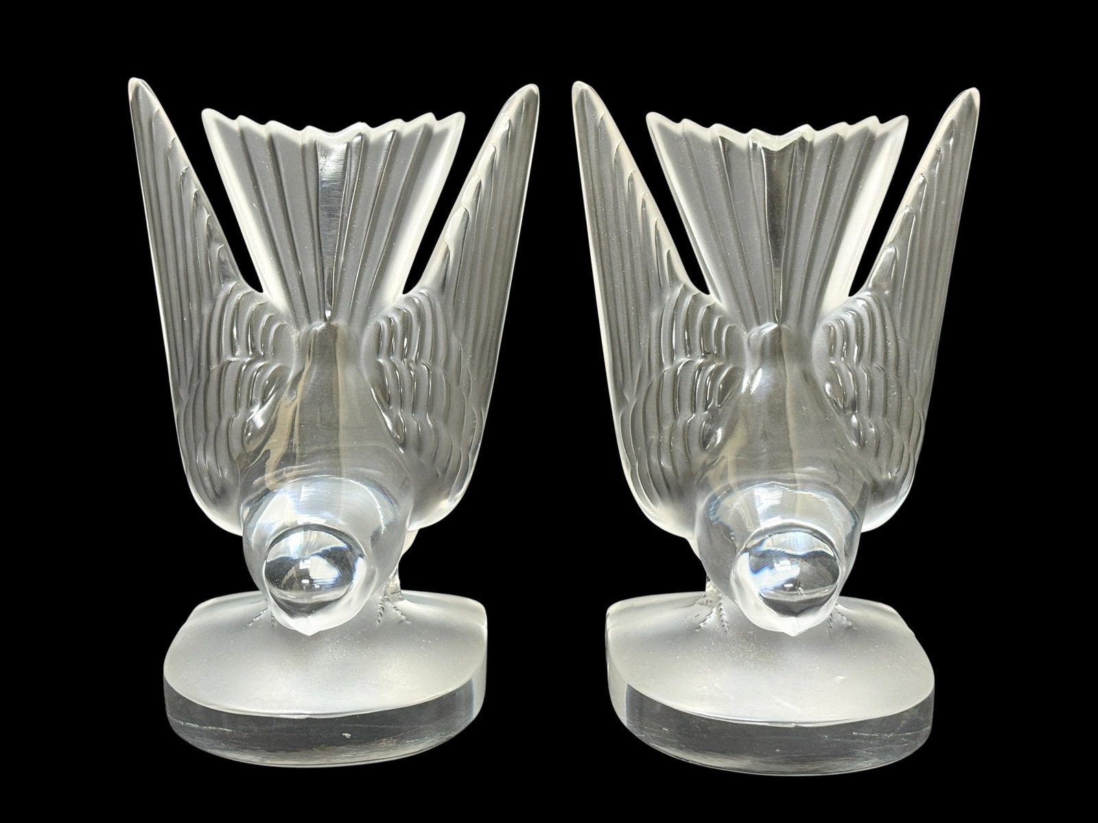 Pair of Signed Lalique "Moineaux" (Sparrow) Crystal Bookends: A classic and highly desirable pair of French frosted and clear crystal bookends in the "Moineaux" pattern by Lalique. Each piece features a stylized sparrow in a graceful, wings-upright pose, showcas