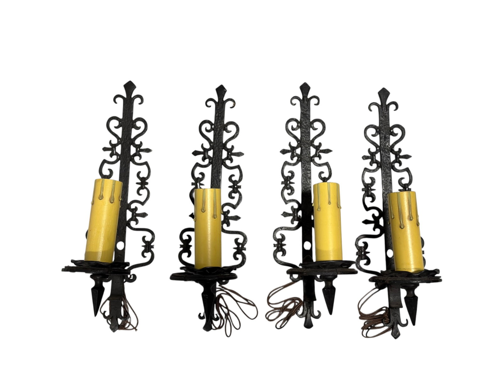 (4) Spanish Revival Wrought Iron Single-Light Sconces: An impressive set of four single-light wall sconces in the Spanish Revival or Gothic Revival style. Each sconce features an elongated, vertically oriented backplate adorned with intricate, symmetrical