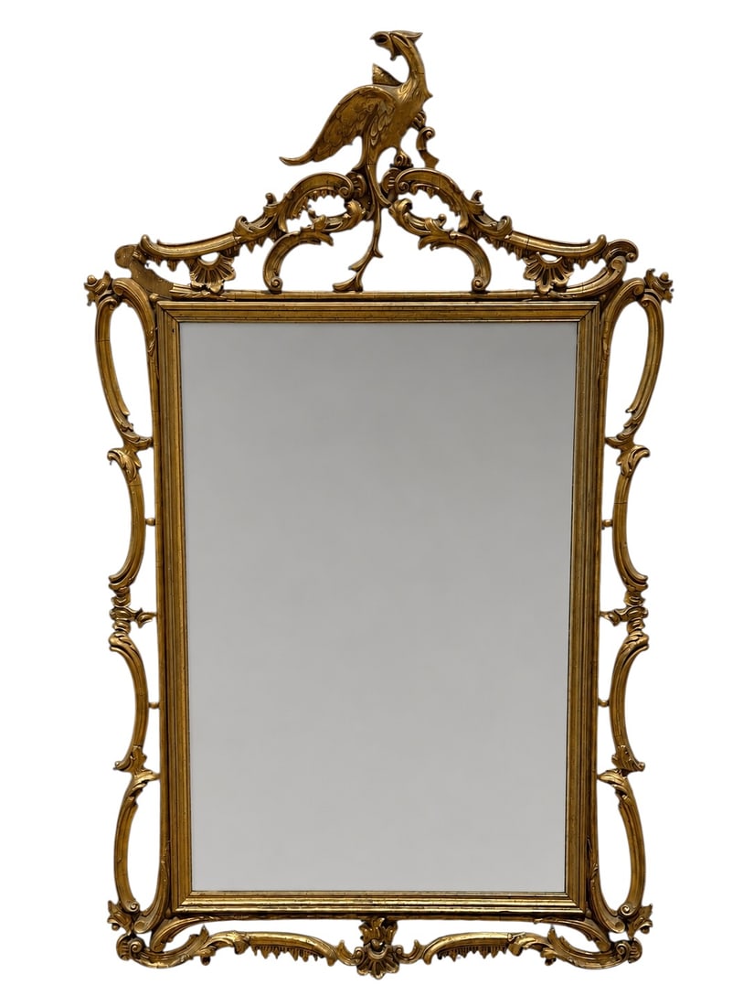 19th c. Ornate Giltwood & Gesso Phoenix Crest Mirror: This impressive, wall-mounted mirror is defined by its dramatic crest, which features a sculptural, mythical phoenix figure perched atop an elaborate arrangement of scrolling, foliate, and shell-inspi
