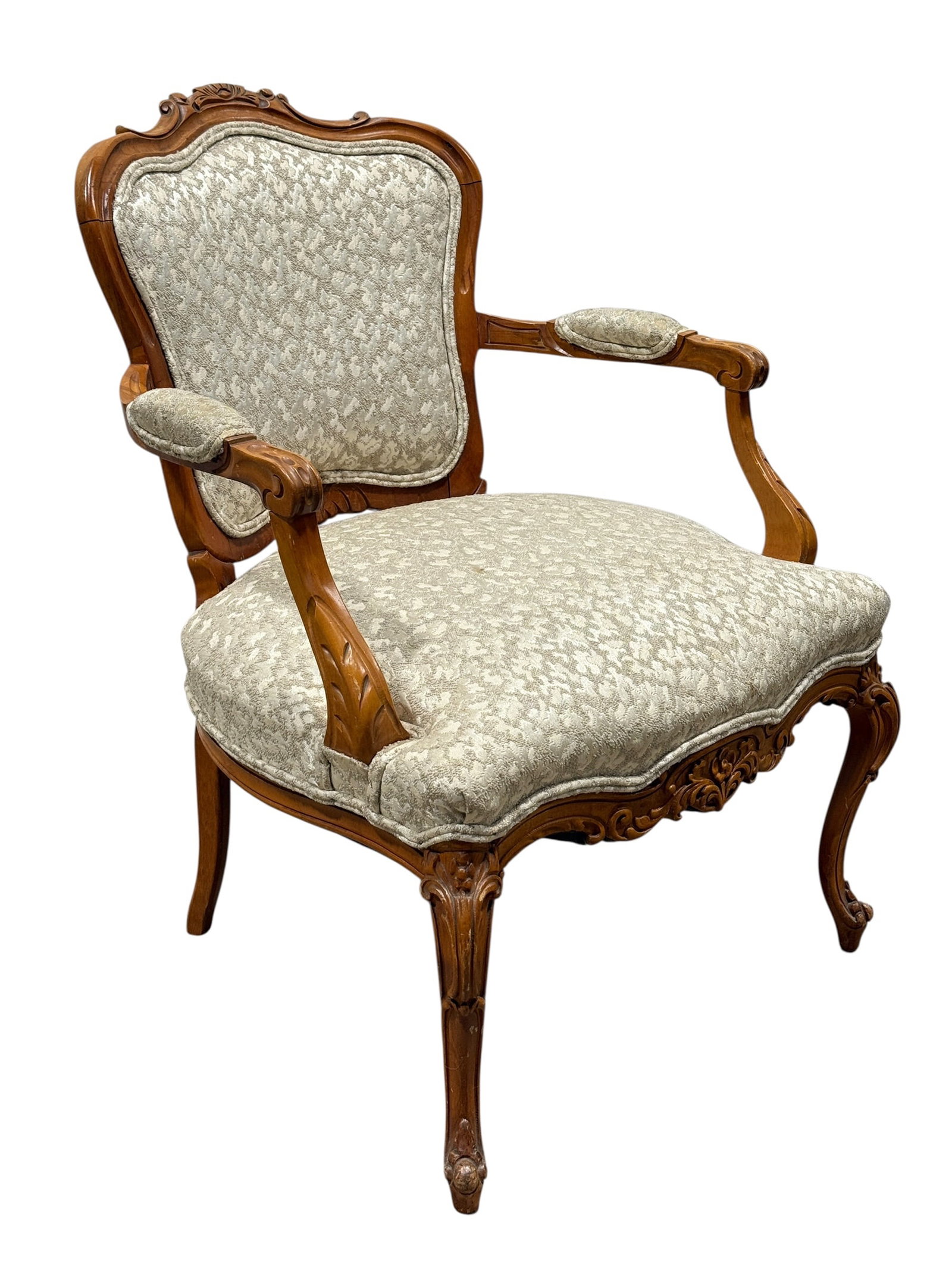 Louis XV Style Carved Walnut Upholstered Armchair: Elegant Louis XV-style walnut armchair featuring a shaped and carved crest rail, molded frame with floral and foliate carvings, scrolling padded arms, serpentine seat rail with carved apron, and grace