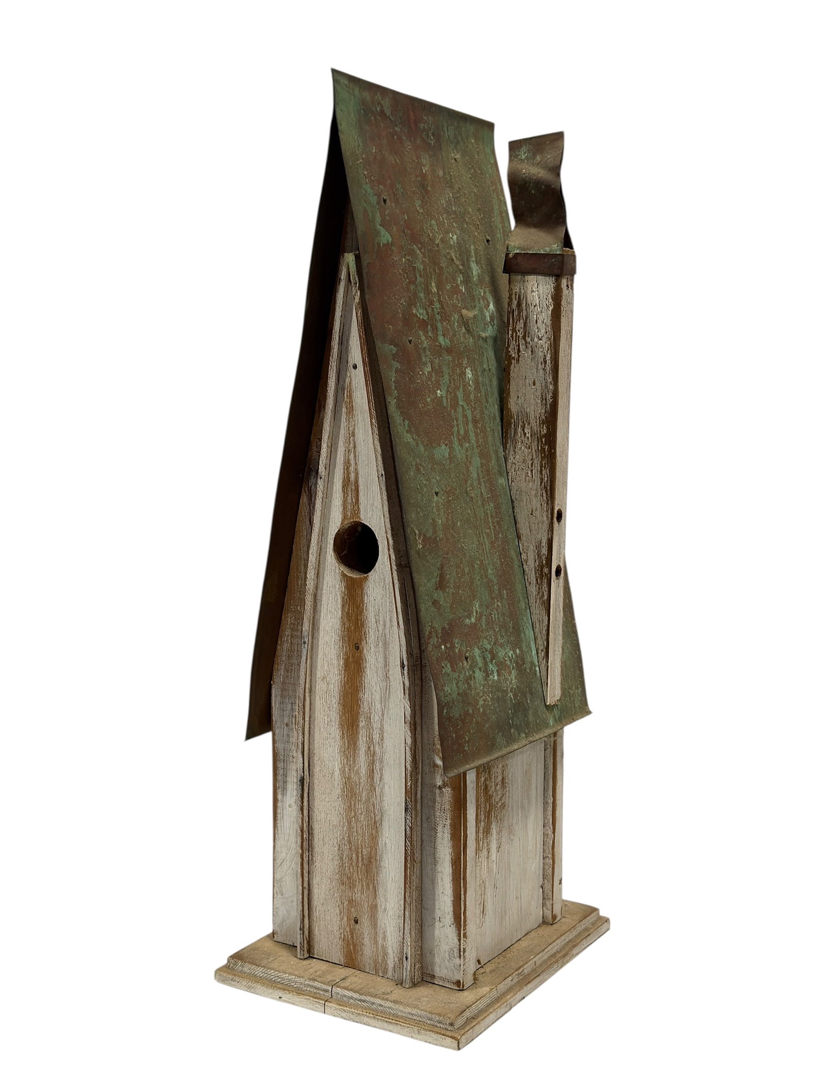 Folk Art Style Weathered Wood and Metal Birdhouse: This charming folk art style decorative birdhouse features a dramatic, high-pitched A-frame design crafted from heavily distressed and whitewashed wood. The steep roofline is clad in sheet metal boast