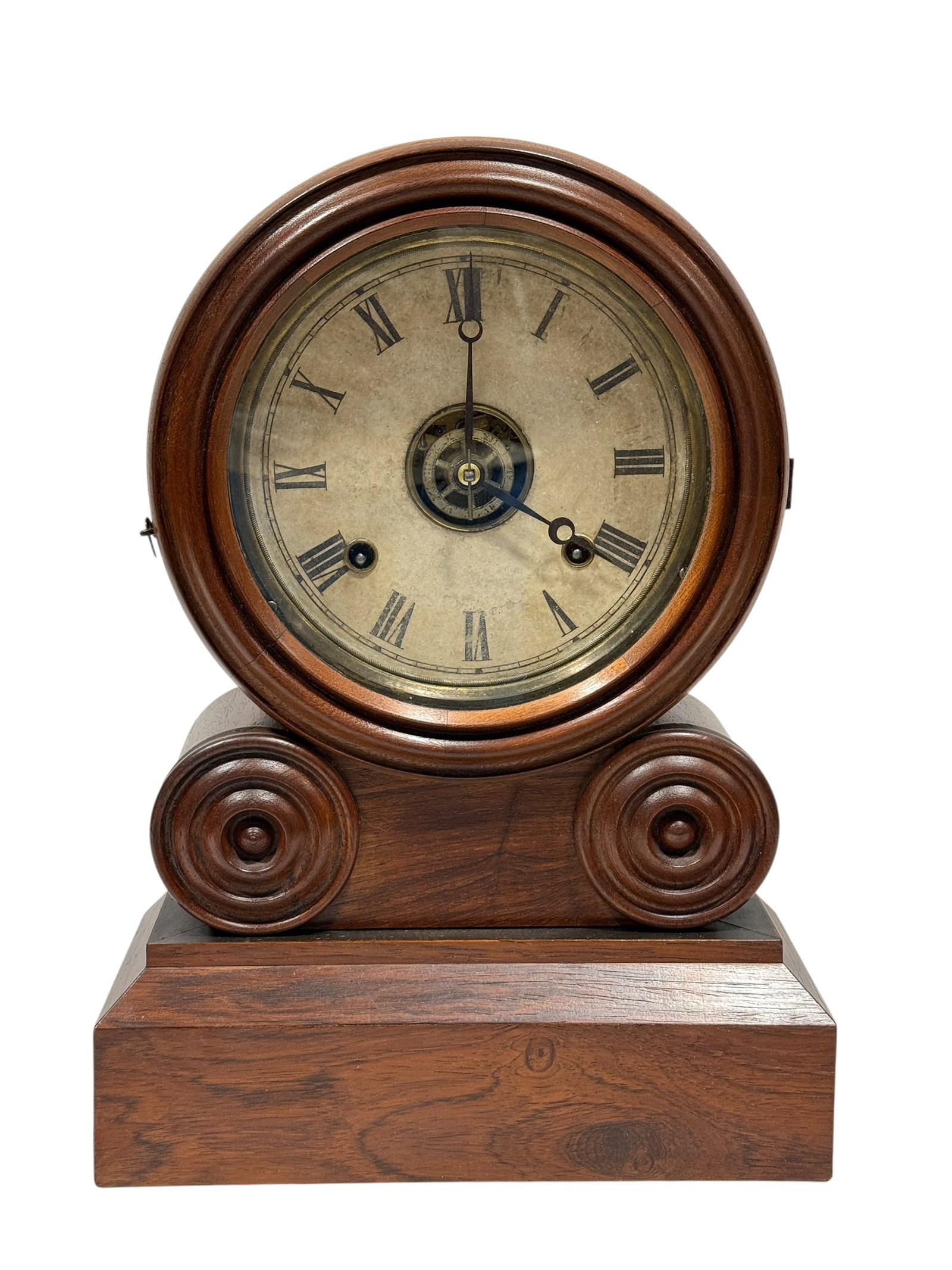 19th Century American Rosewood "Grecian" Mantel Clock by E. Ingraham & Co.: This 19th-century American shelf or mantel clock, manufactured by E. Ingraham & Co. of Bristol, Connecticut, features a distinct "Grecian" style case with a circular dial housing over a stepped base,