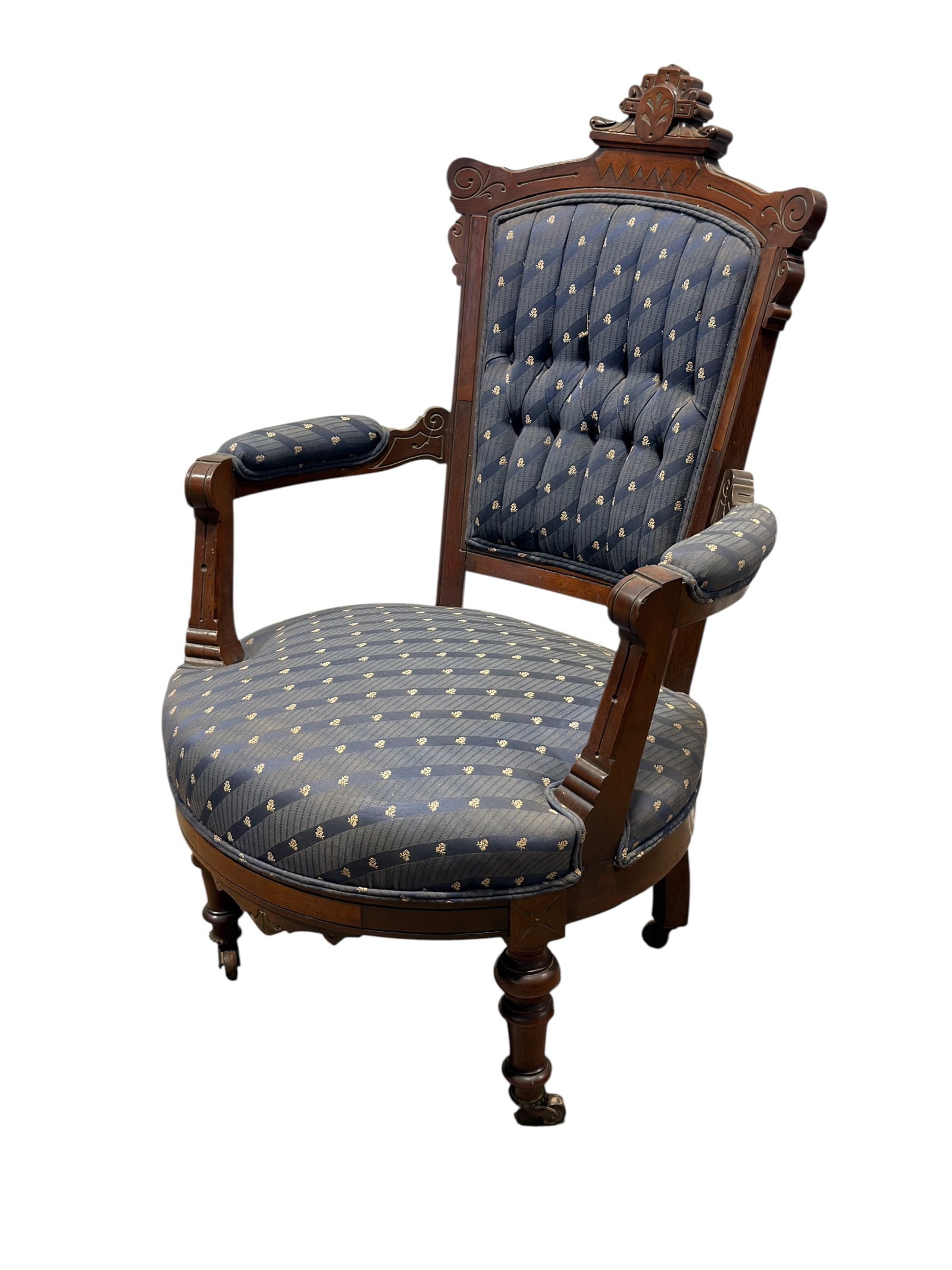 Victorian Renaissance Revival Upholstered Armchair: An antique Victorian Renaissance Revival style upholstered armchair. The carved wooden frame features an elaborate crest rail centered by a prominent, stylized palmette finial over a zigzag chip-carve
