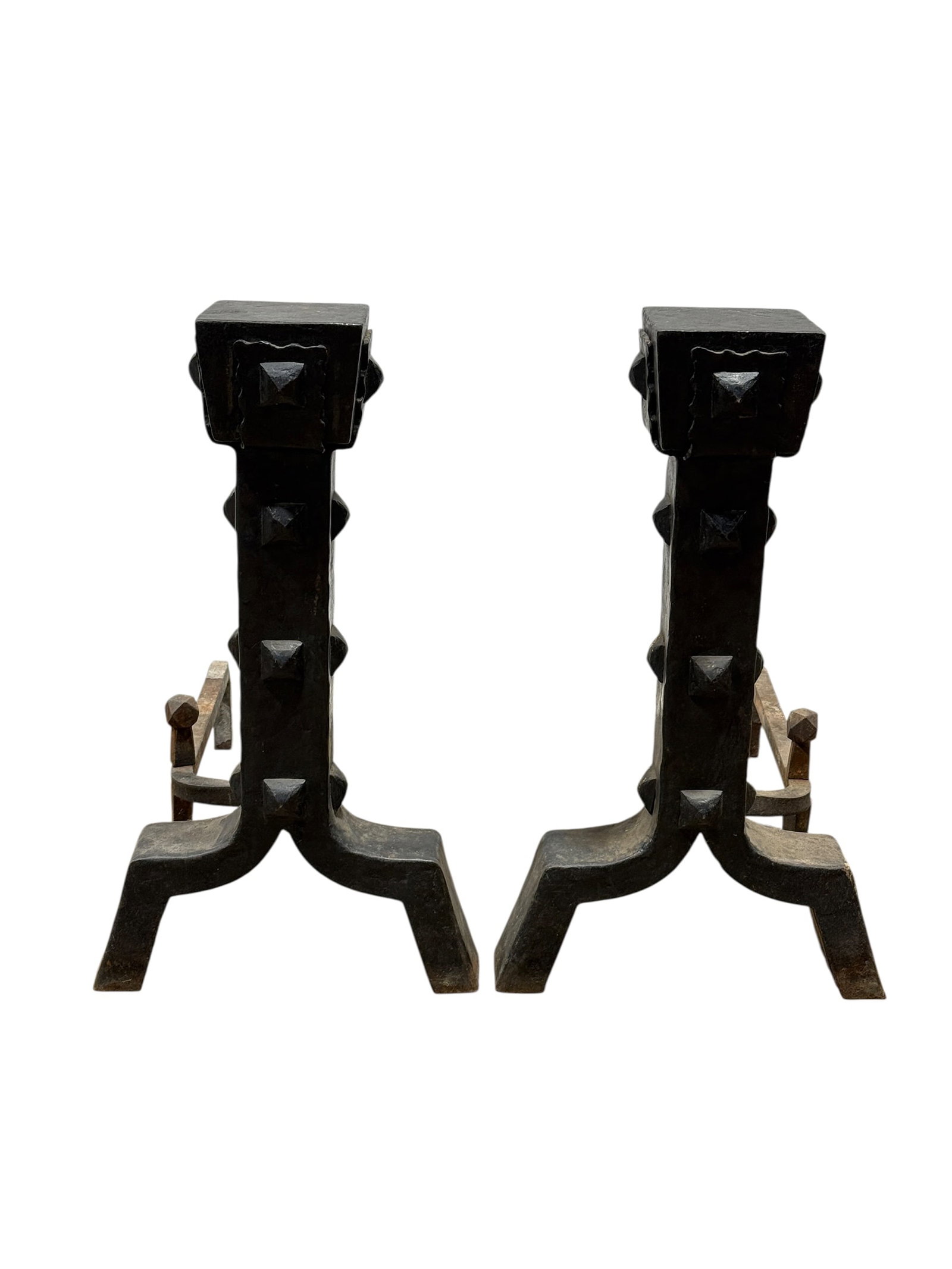 Pair of Studded Wrought Iron Andirons: A pair of heavy architectural wrought iron firedogs or andirons featuring a bold geometric design. Each andiron is formed with a square, flat-topped plinth cap over a tapering square-section shaft ado