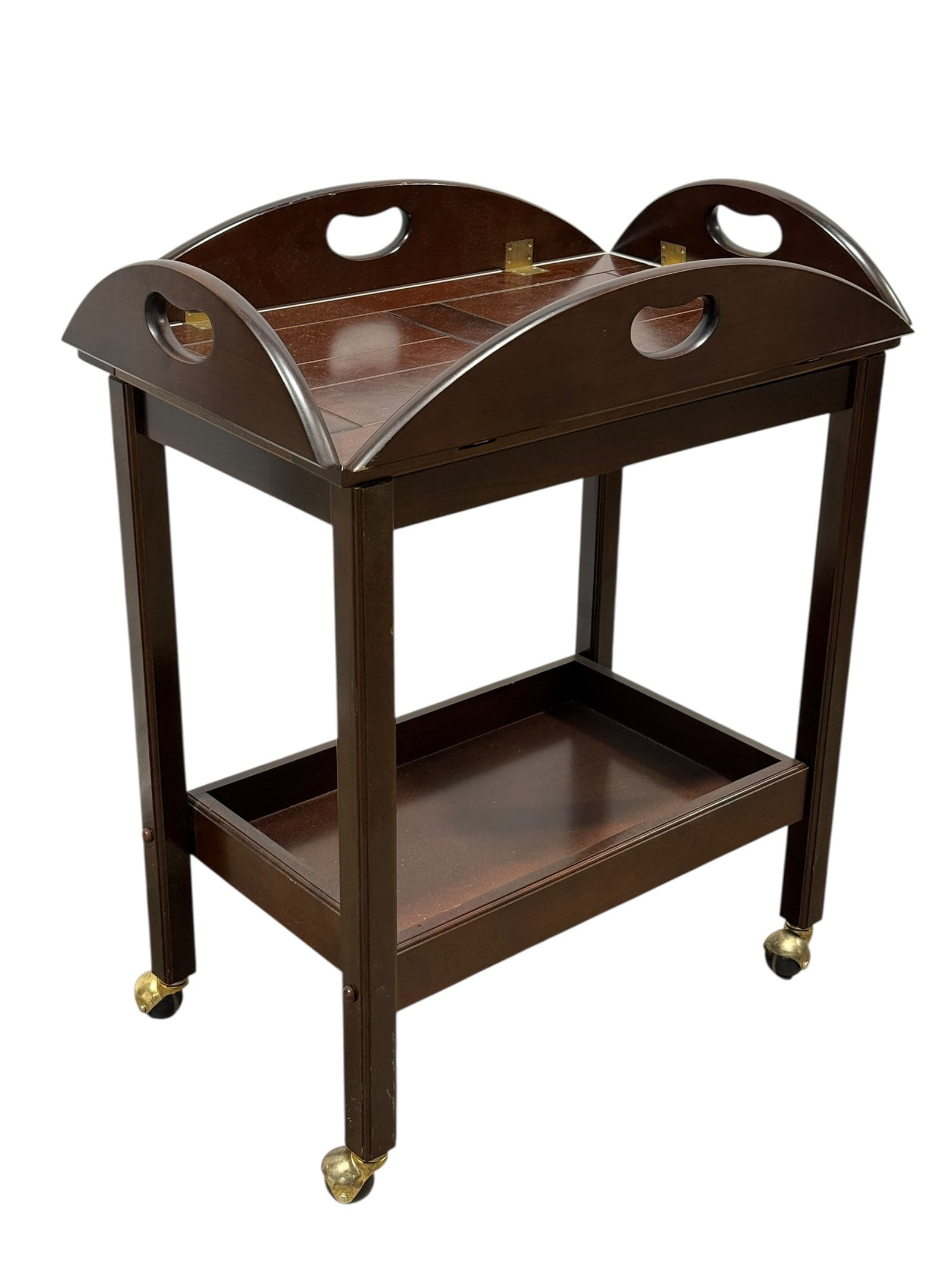 The Bombay Co. Mahogany-Finished Butler's Tray Table on Casters: A traditional Georgian-style tea cart or beverage table by The Bombay Company, featuring a removable butler's tray set upon a rolling two-tier frame. The oval tray top is fitted with four hinged drop-