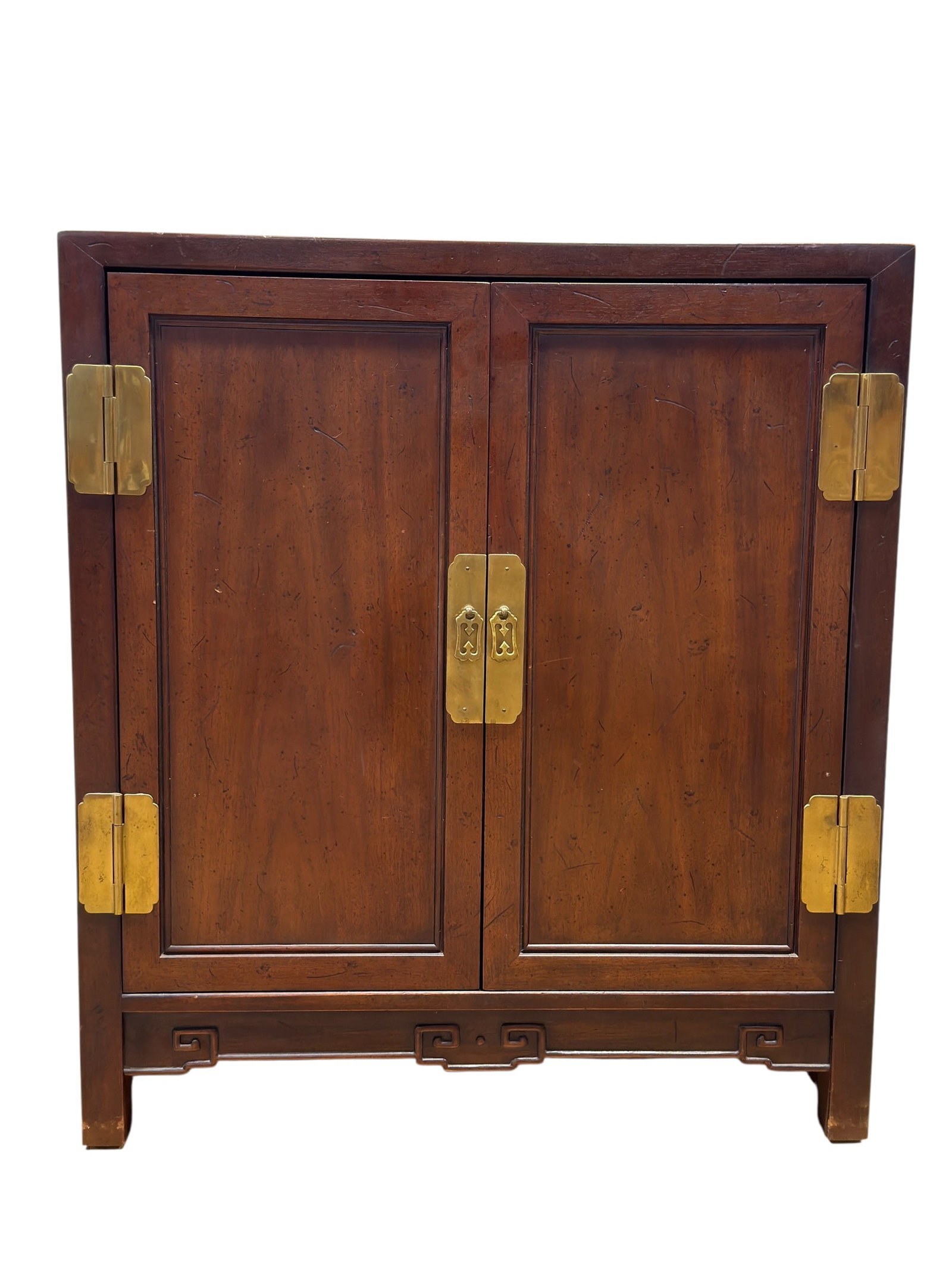20th C. Chinese-Style Walnut 2 Door Cabinet: A decorative Chinese-style cabinet crafted in warm-toned walnut, featuring a rectangular case fitted with two tall recessed-panel doors accented by prominent brass strap hinges and matching rectangula