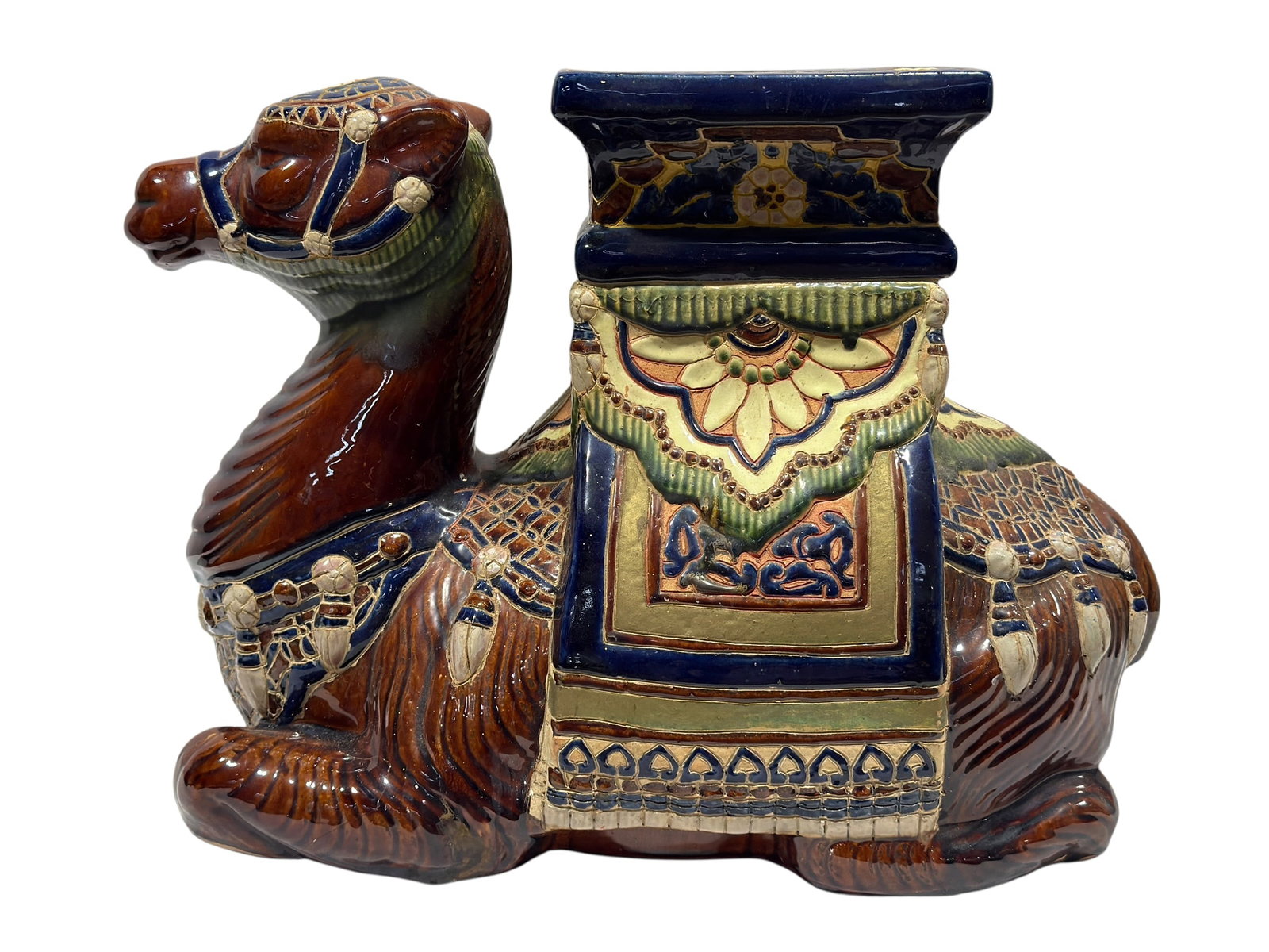 Glazed Ceramic Camel Garden Seat: A whimsical mid-20th-century glazed ceramic garden seat or side table modeled as a recumbent dromedary camel, richly decorated in a vivid Moorish-inspired palette of deep cobalt blue, chestnut brown, 