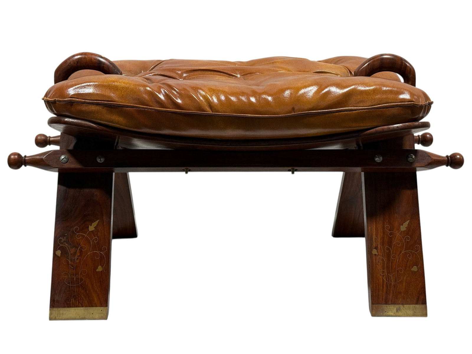 Anglo Indian Brass Inlaid Rosewood Camel Saddle Stool: A distinctive Anglo-Indian camel saddle stool crafted in richly toned rosewood, featuring a broad rectangular seat fitted with a deeply button-tufted caramel-brown leather cushion. The saddle-inspired