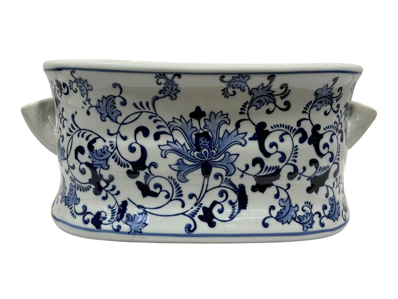 Blue & White Floral Transferware Porcelain Jardiniere: This handsome oversized porcelain jardinière features a graceful oval form with molded side handles and a crisp white glazed ground richly decorated in an elegant cobalt blue floral and scrolling fol