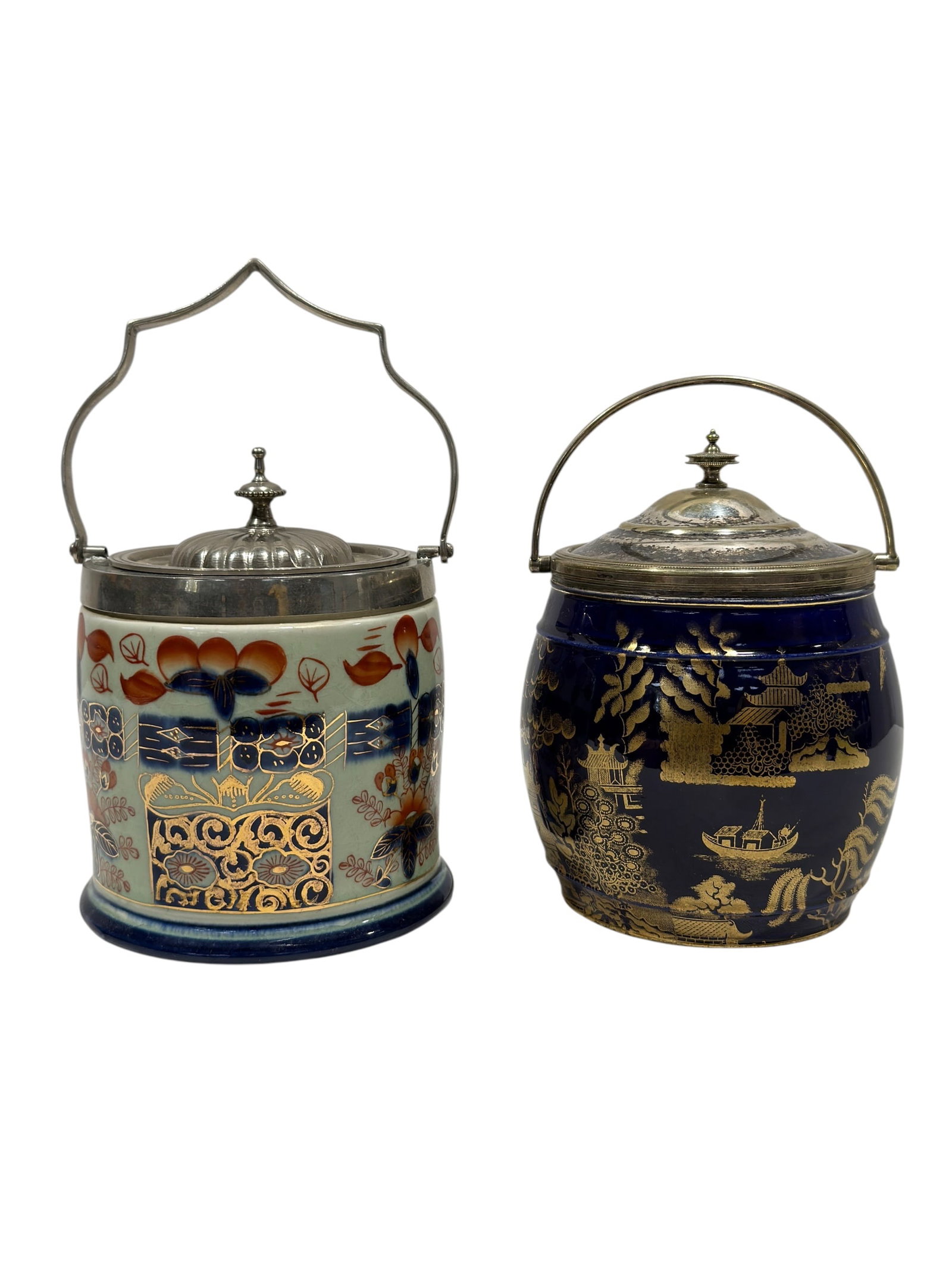 Pair of Wedgwood & Continental Ceramic Biscuit Jars w/ Silverplate Mounts: A decorative pair of late 19th- to early 20th-century ceramic biscuit jars, each of rounded barrel form and fitted with silverplate collars, removable domed lids, and swing handles. The cobalt-blue ja
