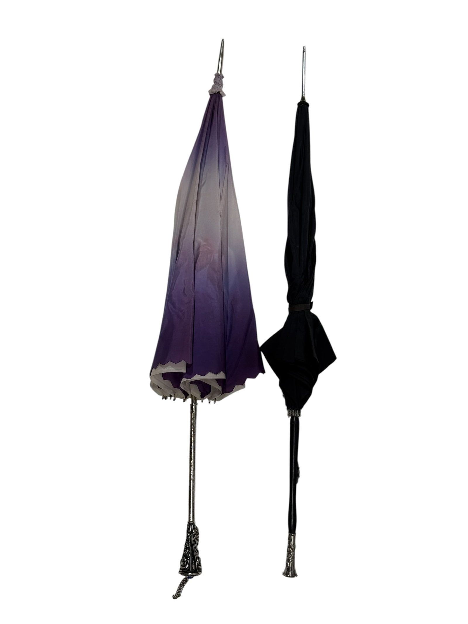 Pair of Vintage Ladies' Ornate Silver Handled Parasols / Umbrellas: A decorative pair of vintage ladies’ parasols or umbrellas, each combining a slender shaft with elaborate silver metal mounts and contrasting fabric canopies. One example features a dramatic lavende