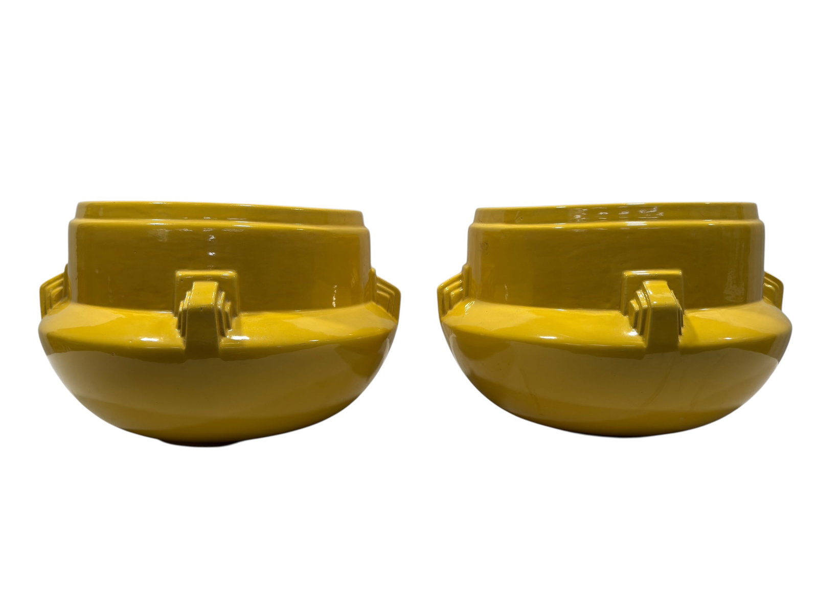 Pair of Art Deco Mustard Yellow Glazed Ceramic Jardinieres: Pair of substantial vintage ceramic jardinieres or cachepots featuring bold architectural Art Deco styling, each formed with a deep cylindrical upper well above a broad rounded lower body and accented