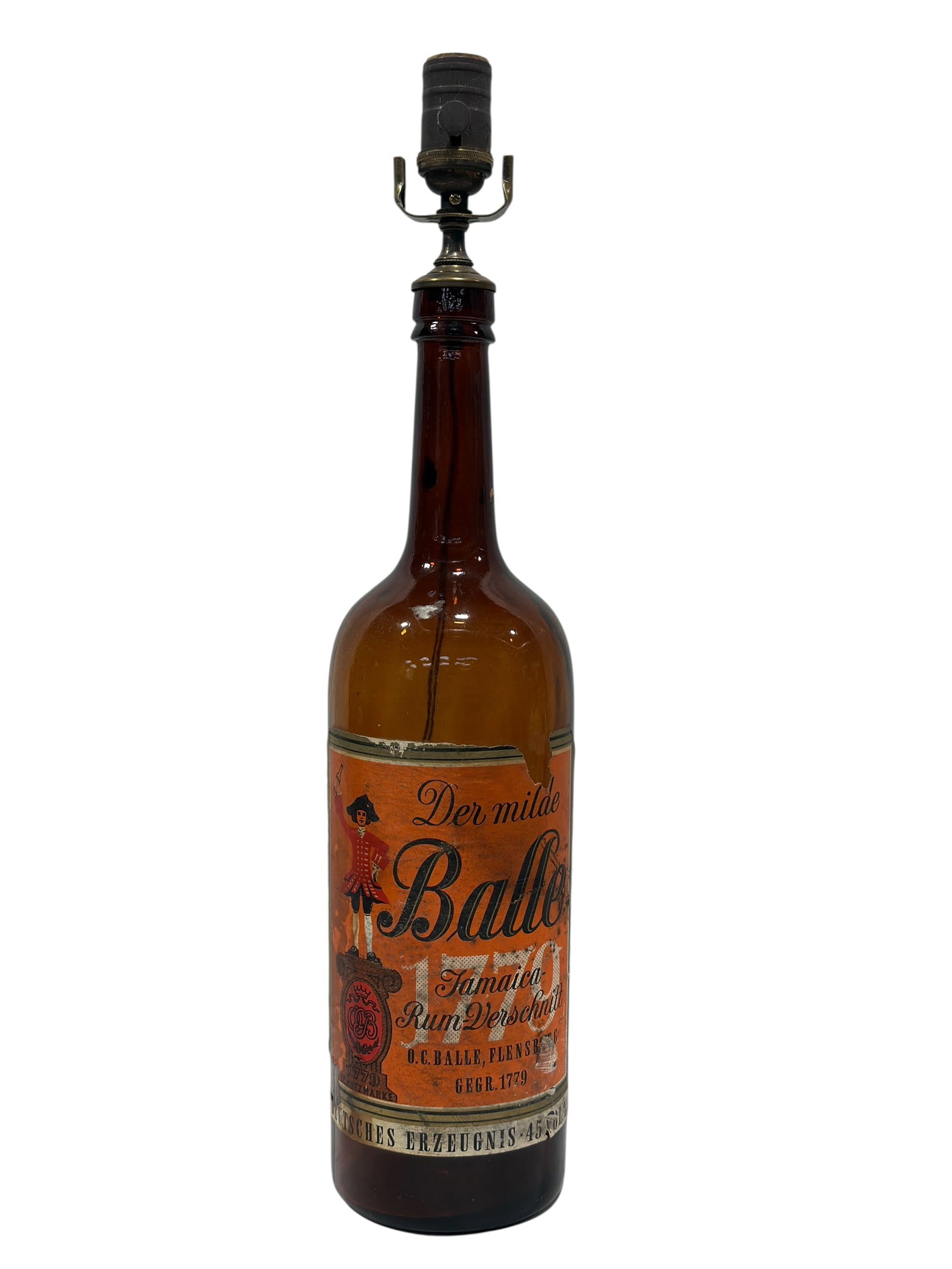 O.C. Balle “Der Milde Balle?? Jamaica Rum Advertising Bottle Table Lamp, Mid-20th Century: Vintage German advertising table lamp fashioned from a large amber glass O.C. Balle, Flensburg rum bottle, retaining its colorful orange paper label for “Der milde Balle – Jamaica Rum-Verschnitt&r