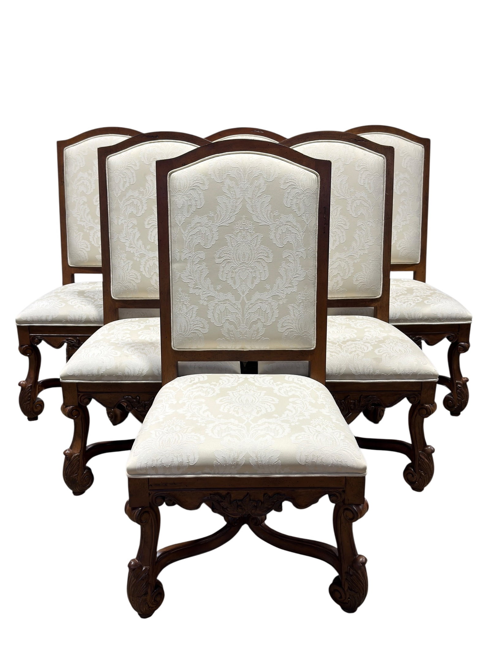Set of Six Traditional Carved Wood Dining Chairs with Damask Upholstery: Set of six substantial traditional-style dining chairs featuring richly finished wood frames, tall gently arched upholstered backs, and generously padded seats covered in an elegant ivory-on-cream dam