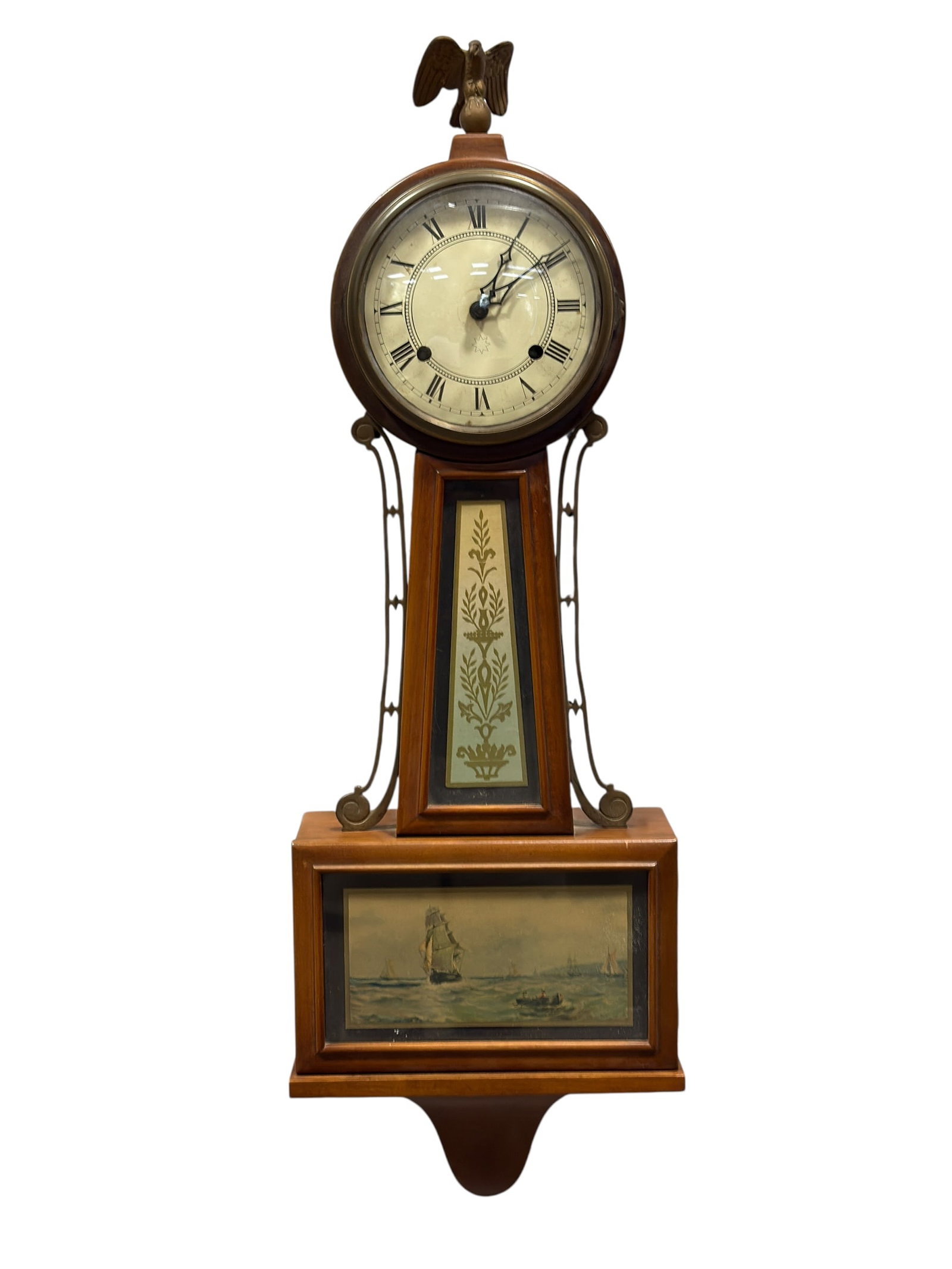 Early 20th C. Federal Revival Banjo Wall Clock w/ Eagle Finial & Nautical Tablet: Early 20th-century Federal Revival banjo-form wall clock, crafted in mahogany-toned wood and modeled after the classic American banjo clocks popularized during the Federal period. The clock features a