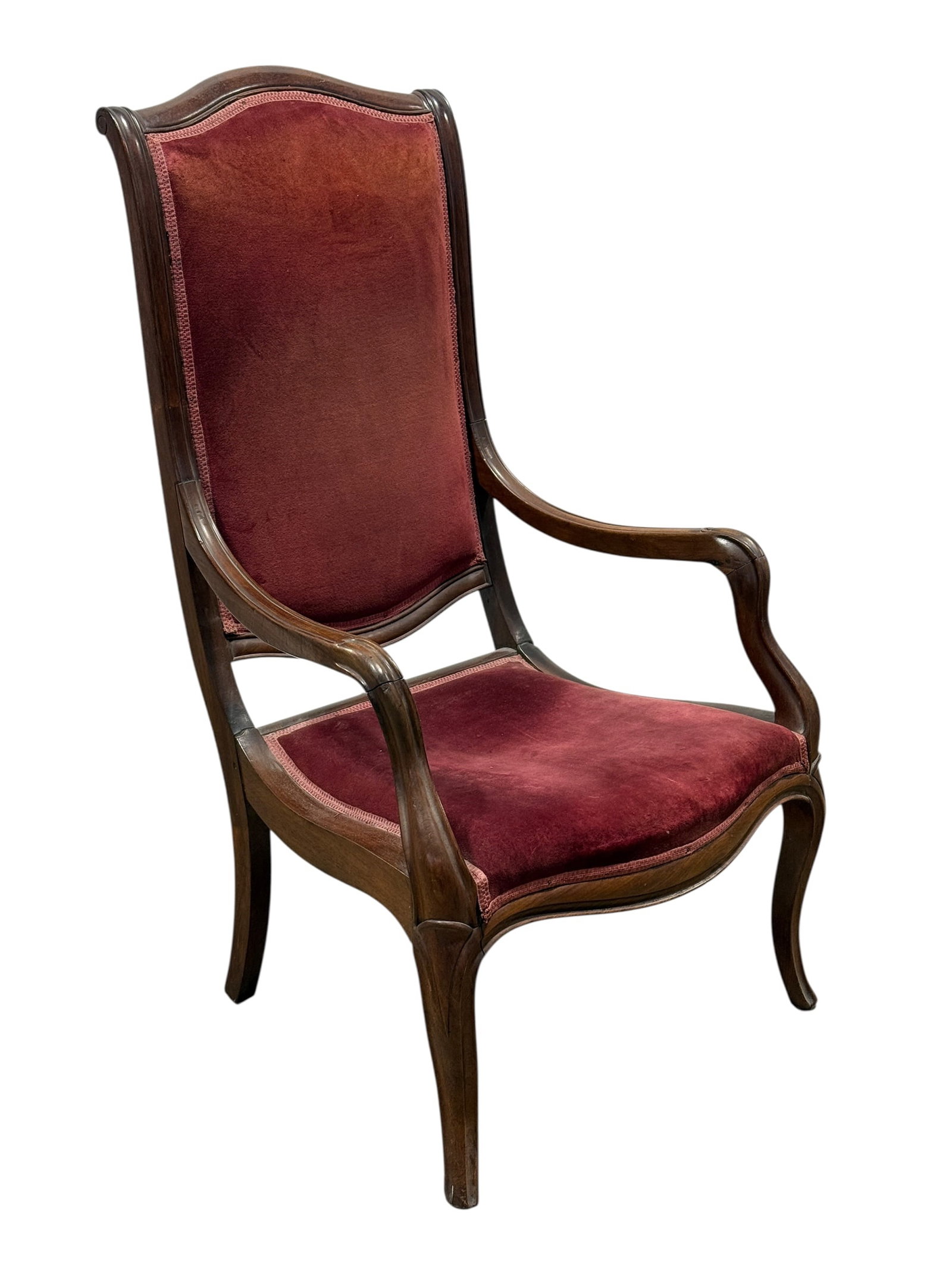 Victorian Mahogany Parlor Armchair: An antique mahogany parlor armchair featuring a molded, serpentine crest rail over a tall upholstered backrest and seat. The open, swept wooden armrests trace a fluid downward curve toward the seat fr