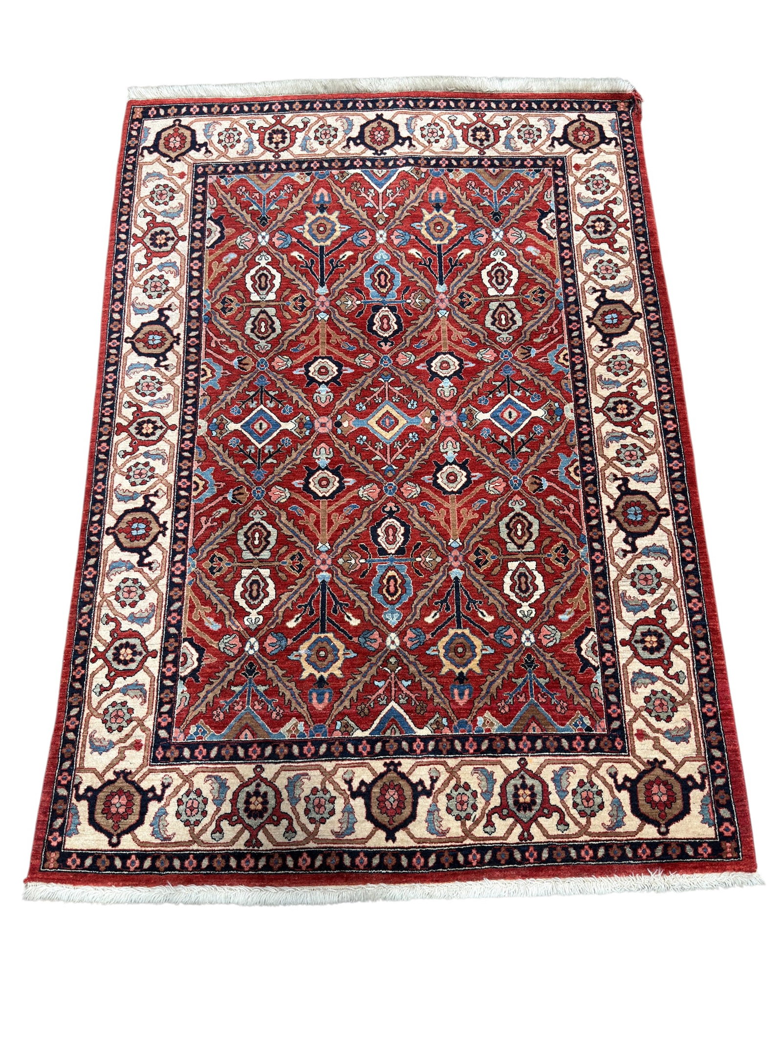 Hand-Knotted Persian-Style Floral Area Rug: Finely patterned hand-knotted wool area rug displaying a richly saturated red field organized with repeating geometric floral and foliate motifs in shades of navy, powder blue, ivory, tan, salmon, and