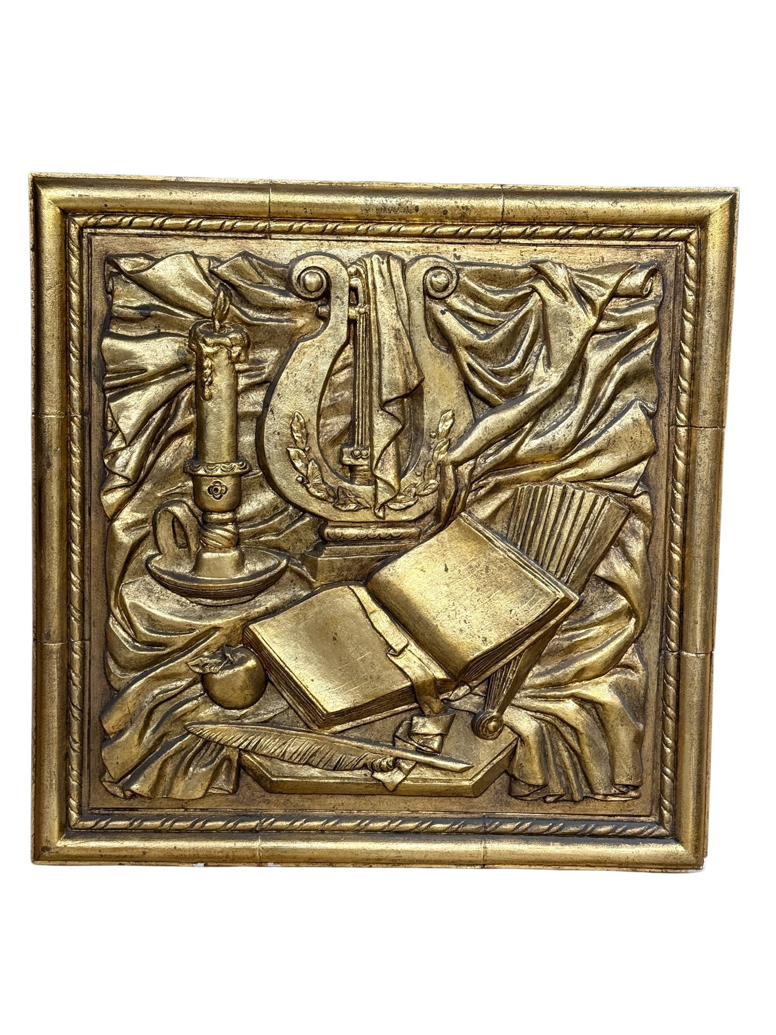 Neoclassical Revival Gilt Relief Wall Plaque: Decorative square wall plaque executed in high-relief with an antiqued gilt finish, presenting a richly modeled still-life composition inspired by classical music, literature, and the arts. The