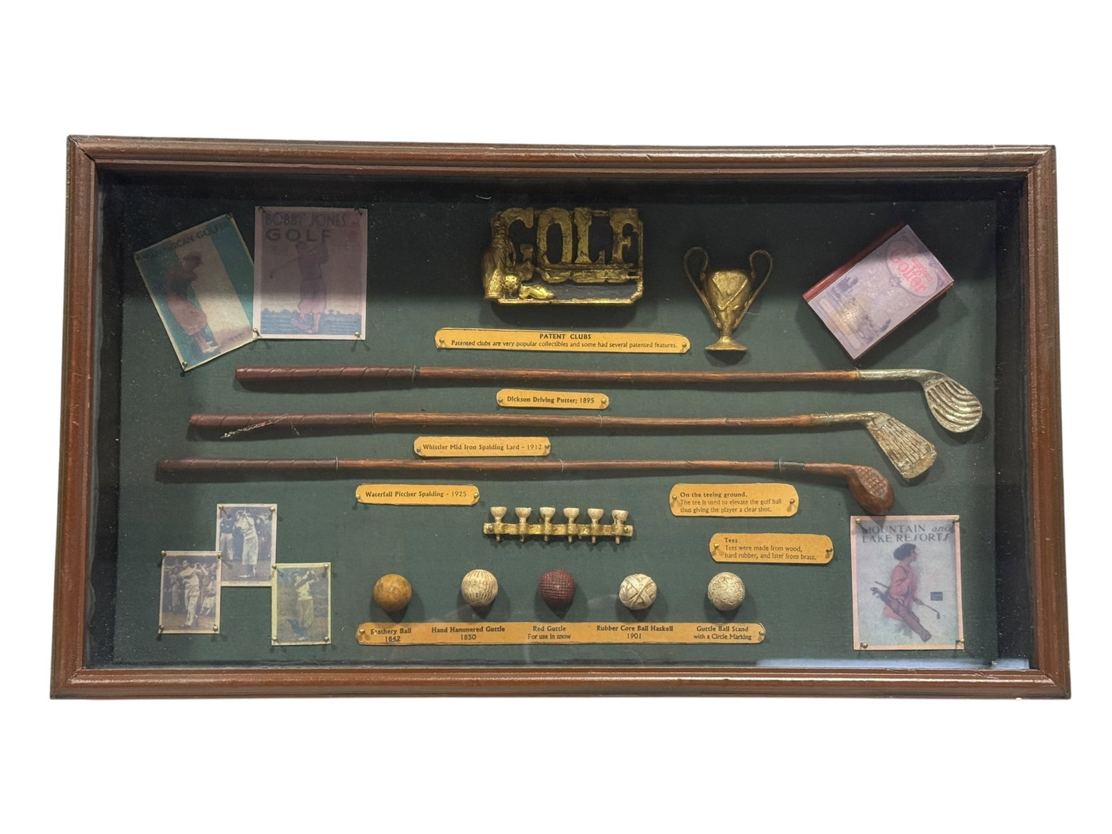 Vintage History of Golf 3-D Shadow Box Display: Vintage decorative “History of Golf” three-dimensional shadow box display, presenting a detailed visual survey of the evolution of golf equipment against a deep green fabric-covered background