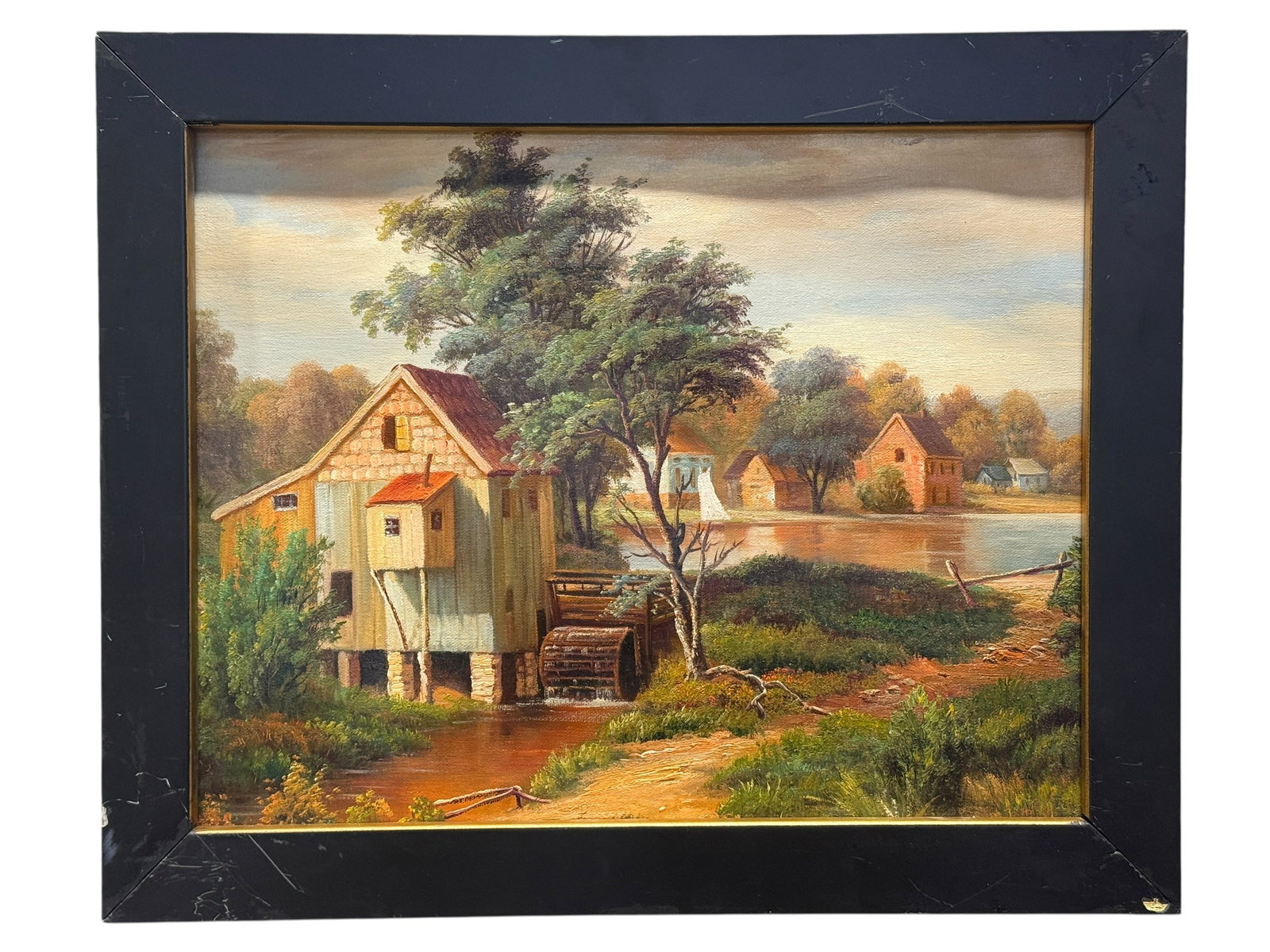 Oil on Canvas River Mill & Village Landscape Painting: Decorative oil on canvas landscape depicting a quiet rural river scene centered around an old watermill with a large wooden waterwheel, surrounded by trees, grassy banks, and a small collection of vil